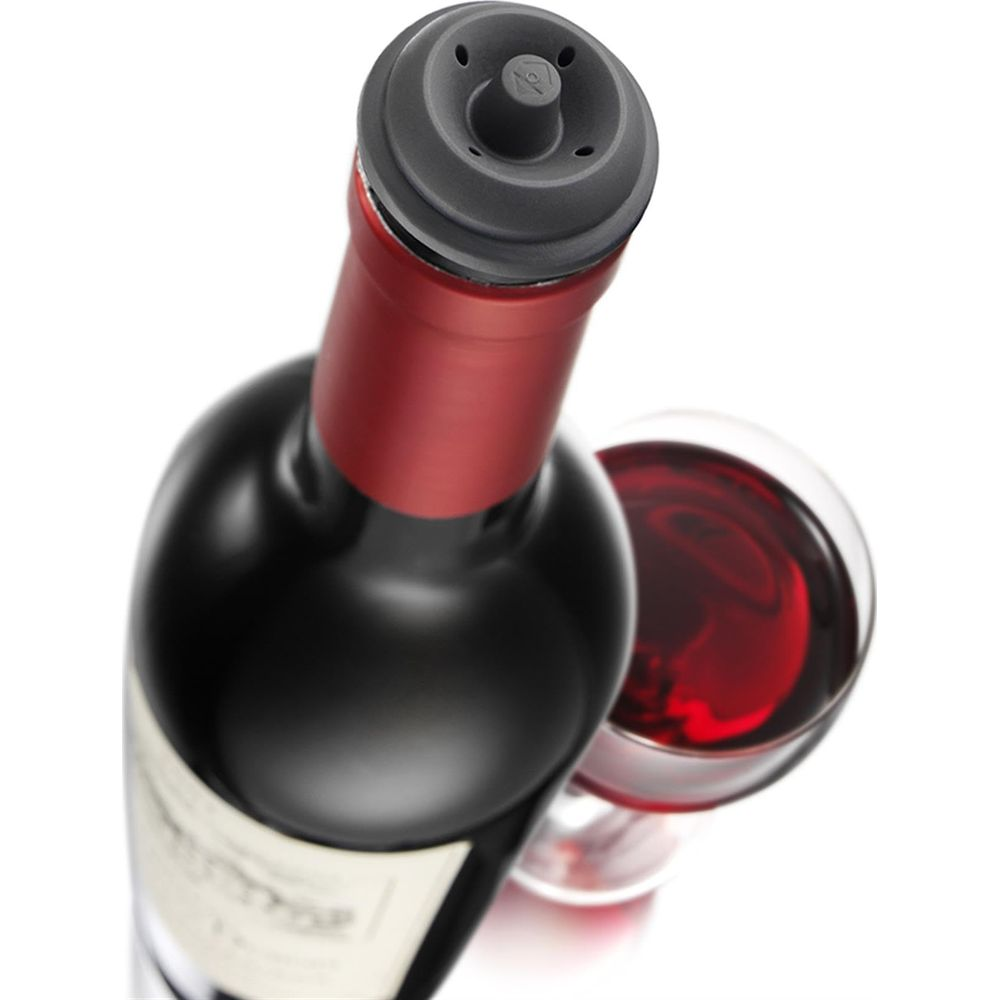 Bottiglia di vino scuro con sigillo rosso e tappo sottovuoto, accanto a un bicchiere di vino rosso.