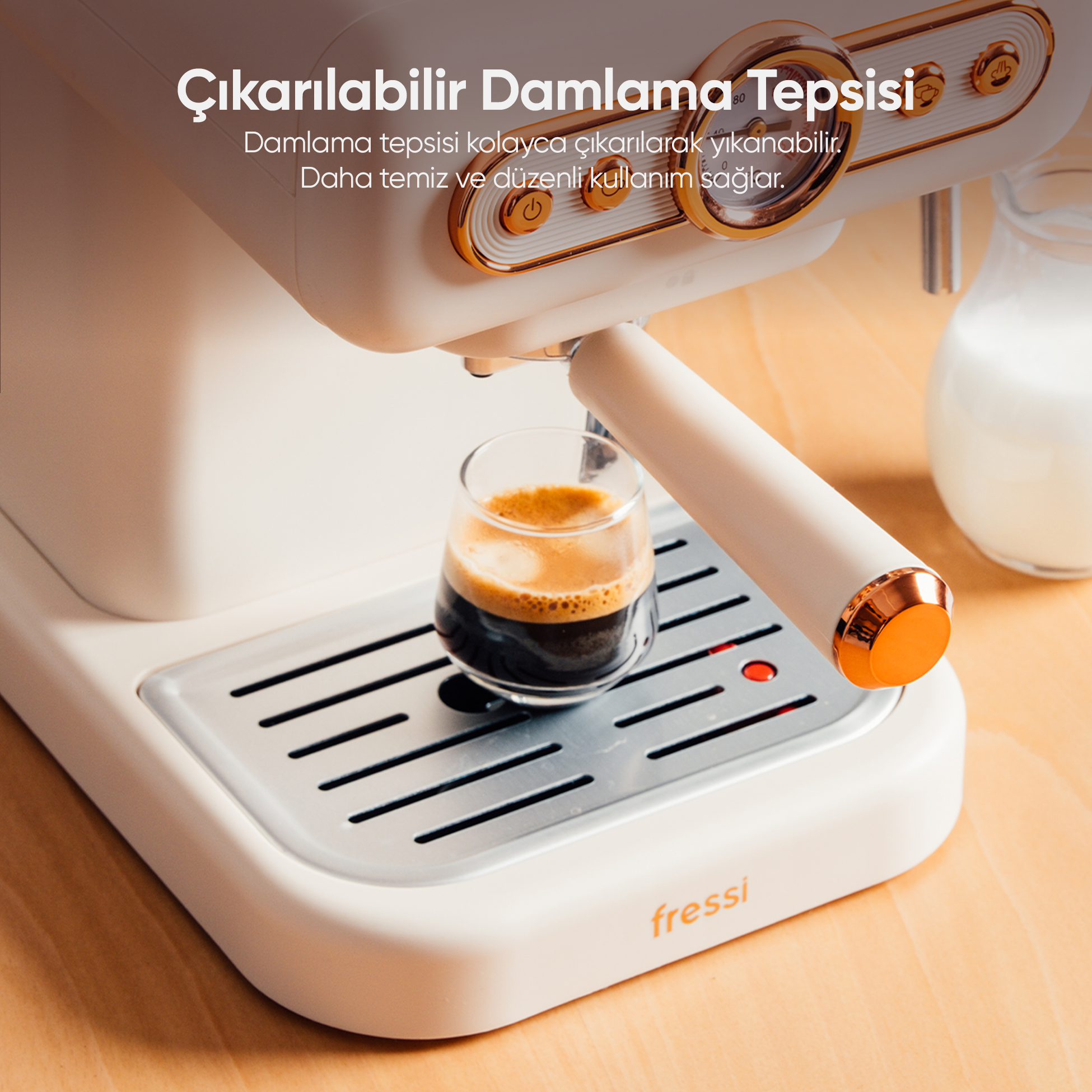 Beyaz bir kahve makinesi, bir bardak espresso ve süt sürahisi.