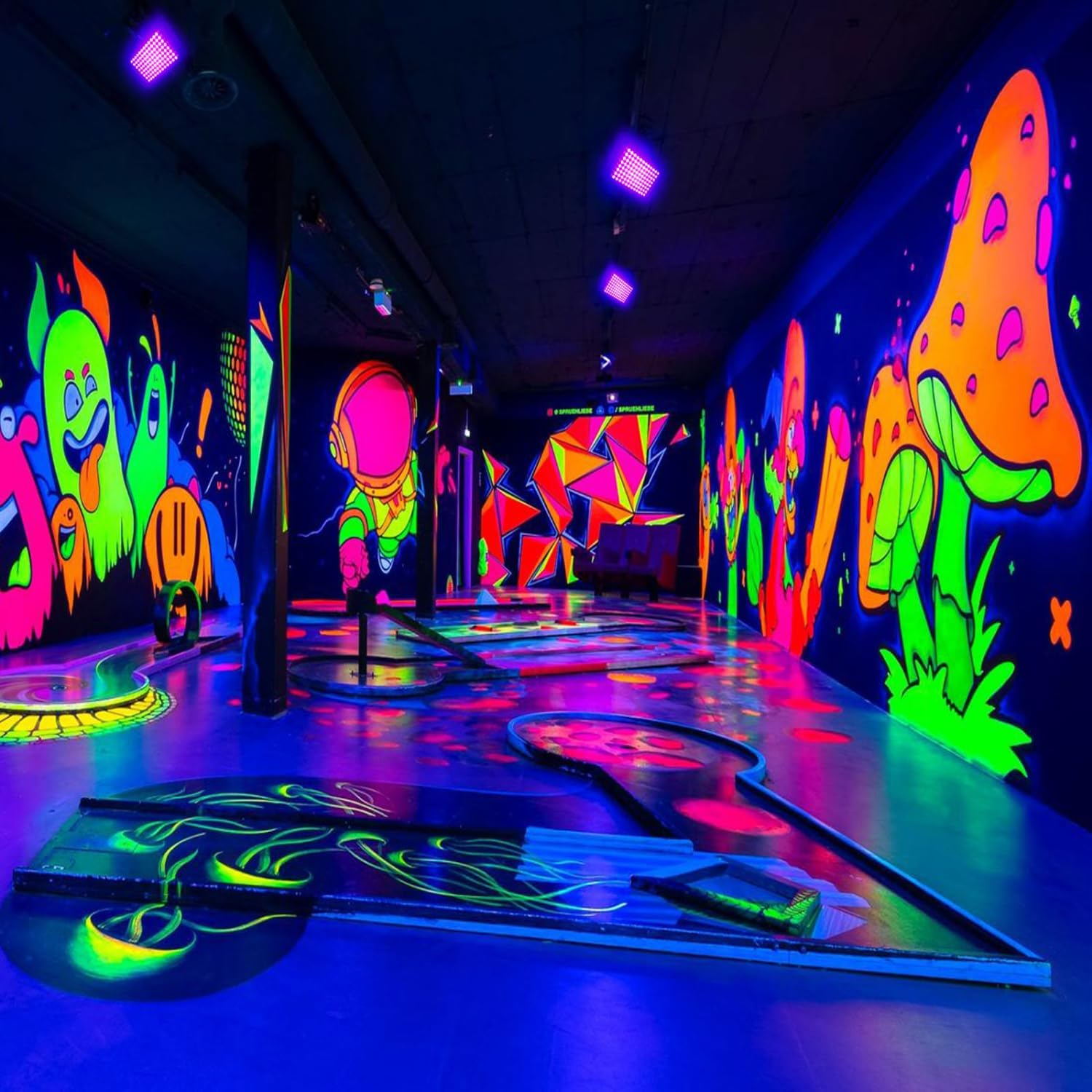Ein Minigolfplatz mit leuchtender Neonkunst an den Wänden und auf dem Boden.