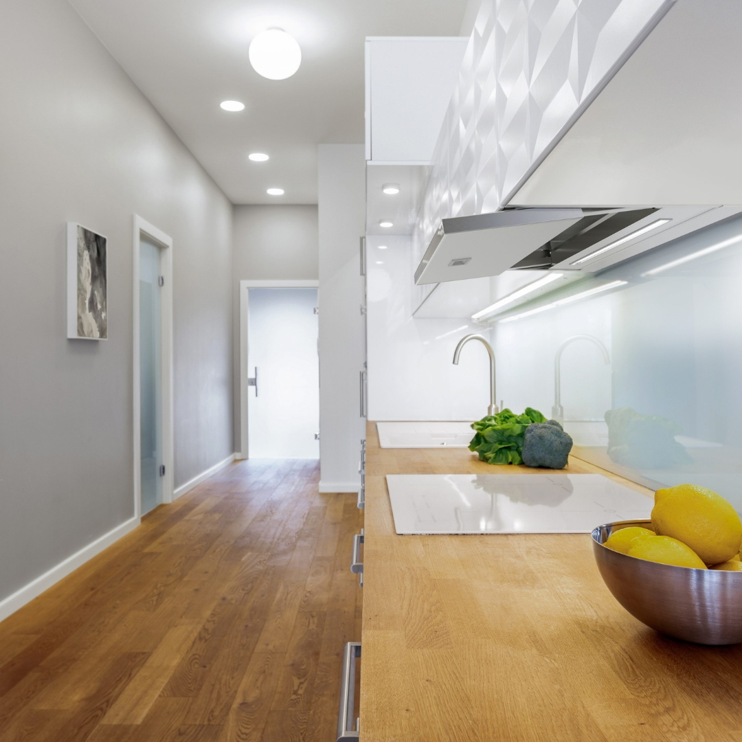 Cucina moderna con piano di lavoro in legno, paraschizzi piastrellato bianco e ciotola.