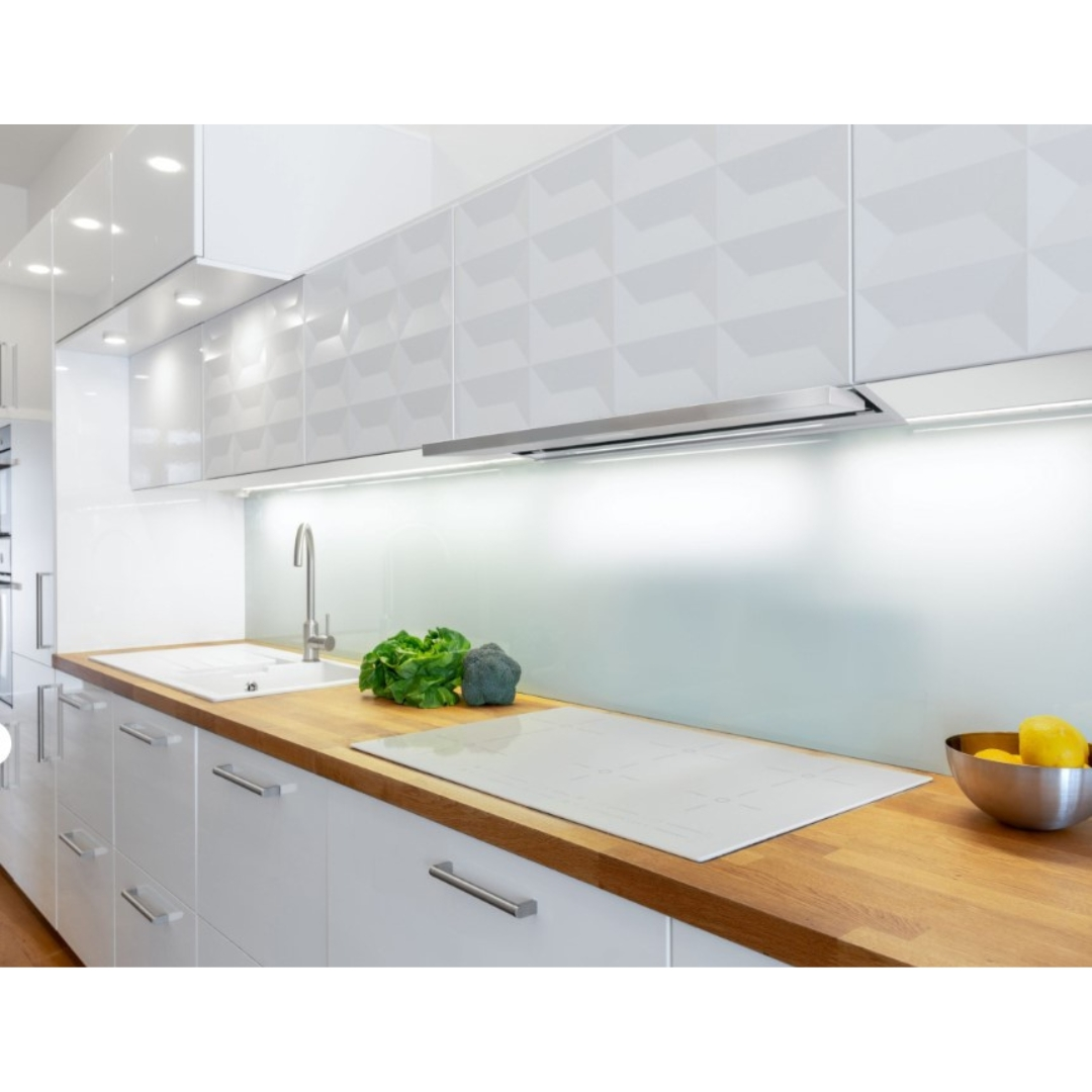 Moderna cucina bianca con piani di lavoro in legno, lavello, fornello e verdure.