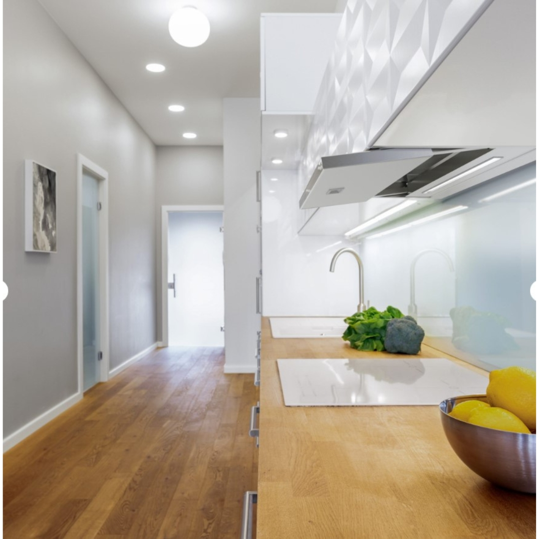 Cucina moderna con superfici in legno, lavello, broccoli e limoni.