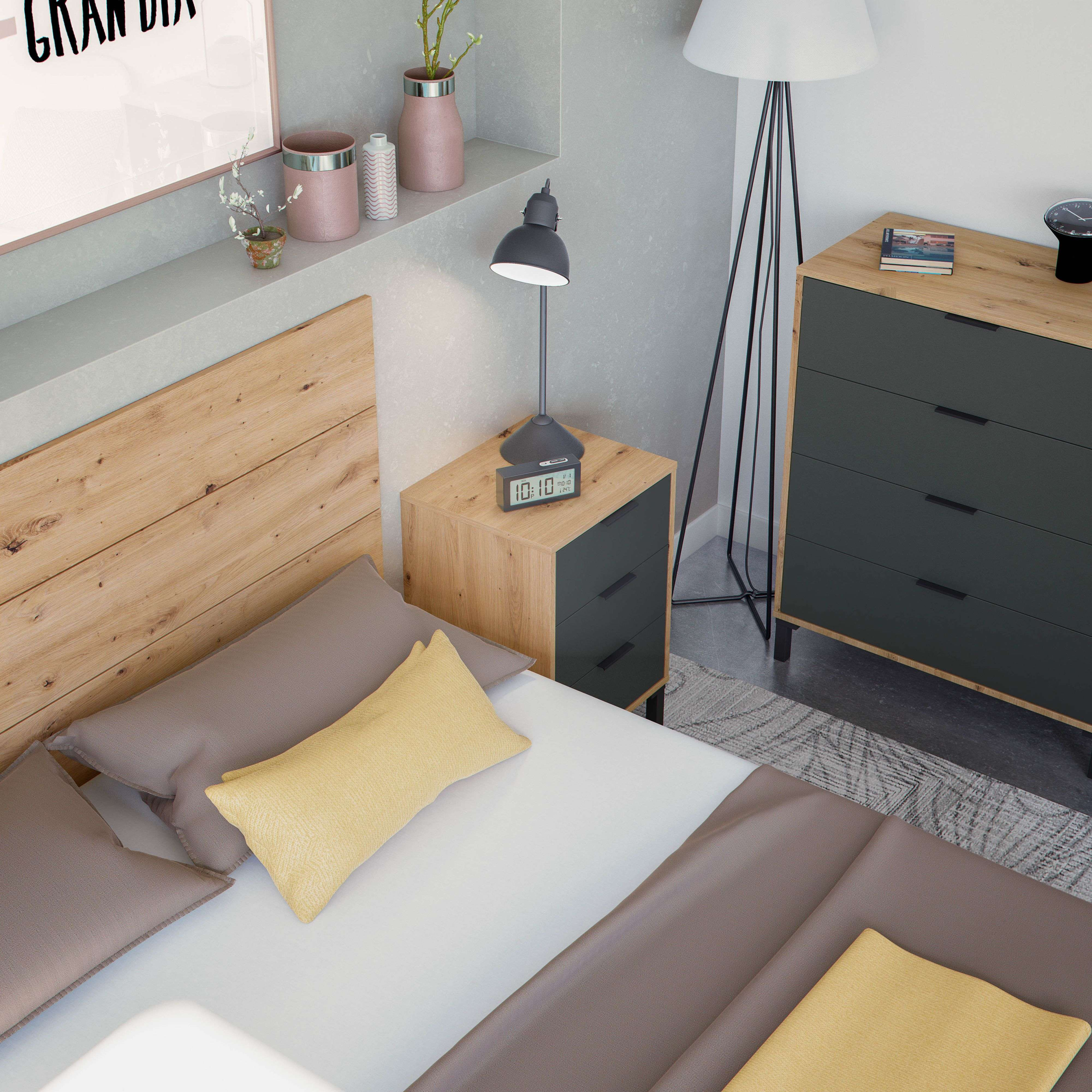 Cama de madera con cojines marrones y amarillos, mesita de noche con lámpara.