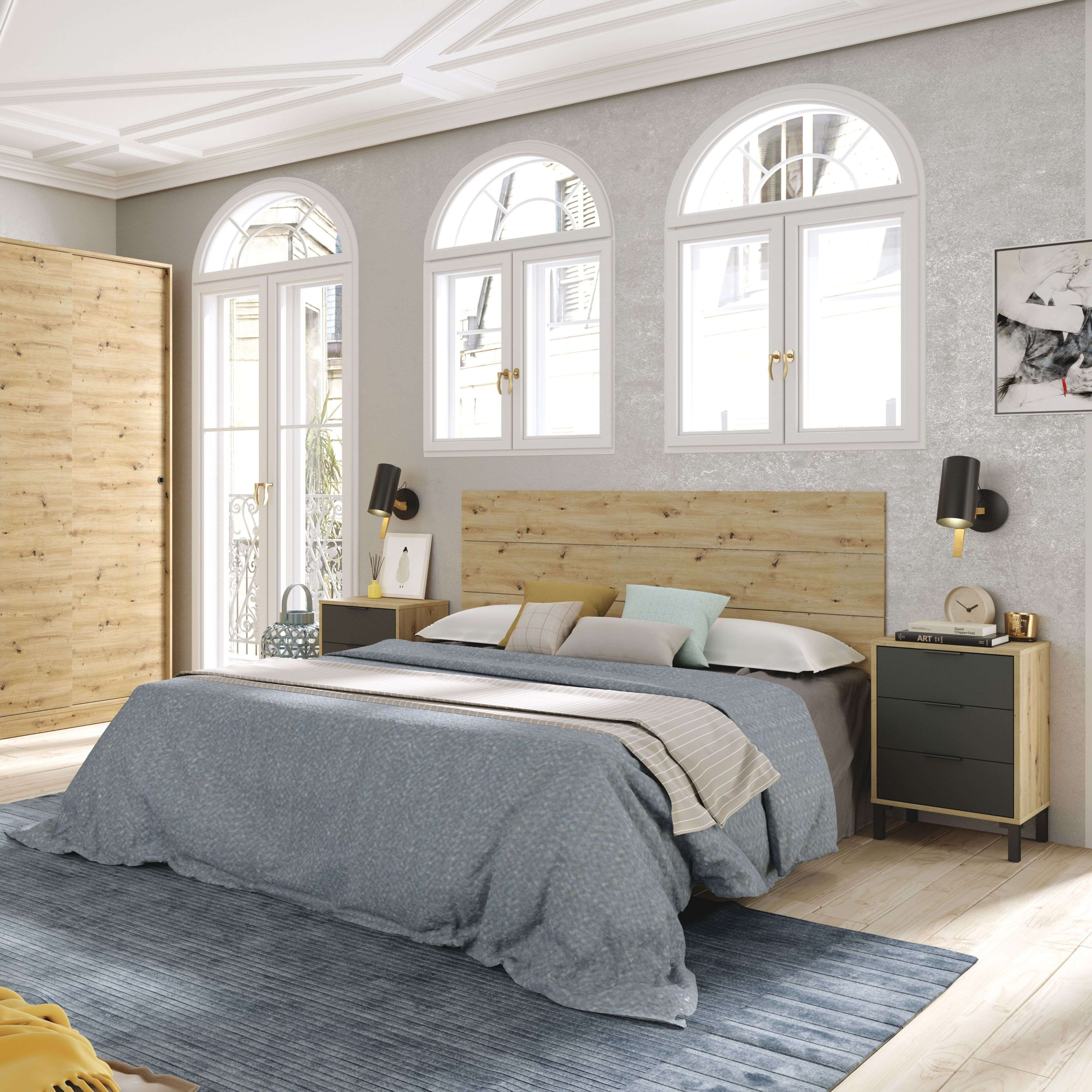 Un dormitorio con cama king-size, cabecero de madera, mesitas de noche, armario y ventanas arqueadas.