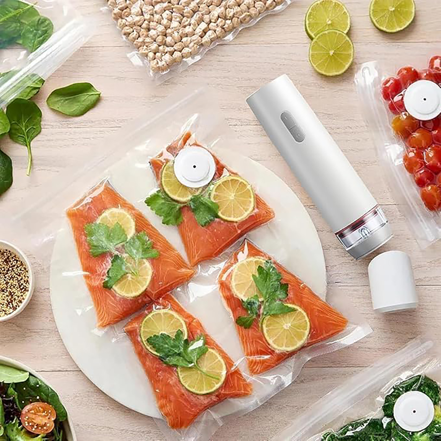 Vakuumiergerät mit Fisch, Limetten, Tomaten, Spinat und Kichererbsen.