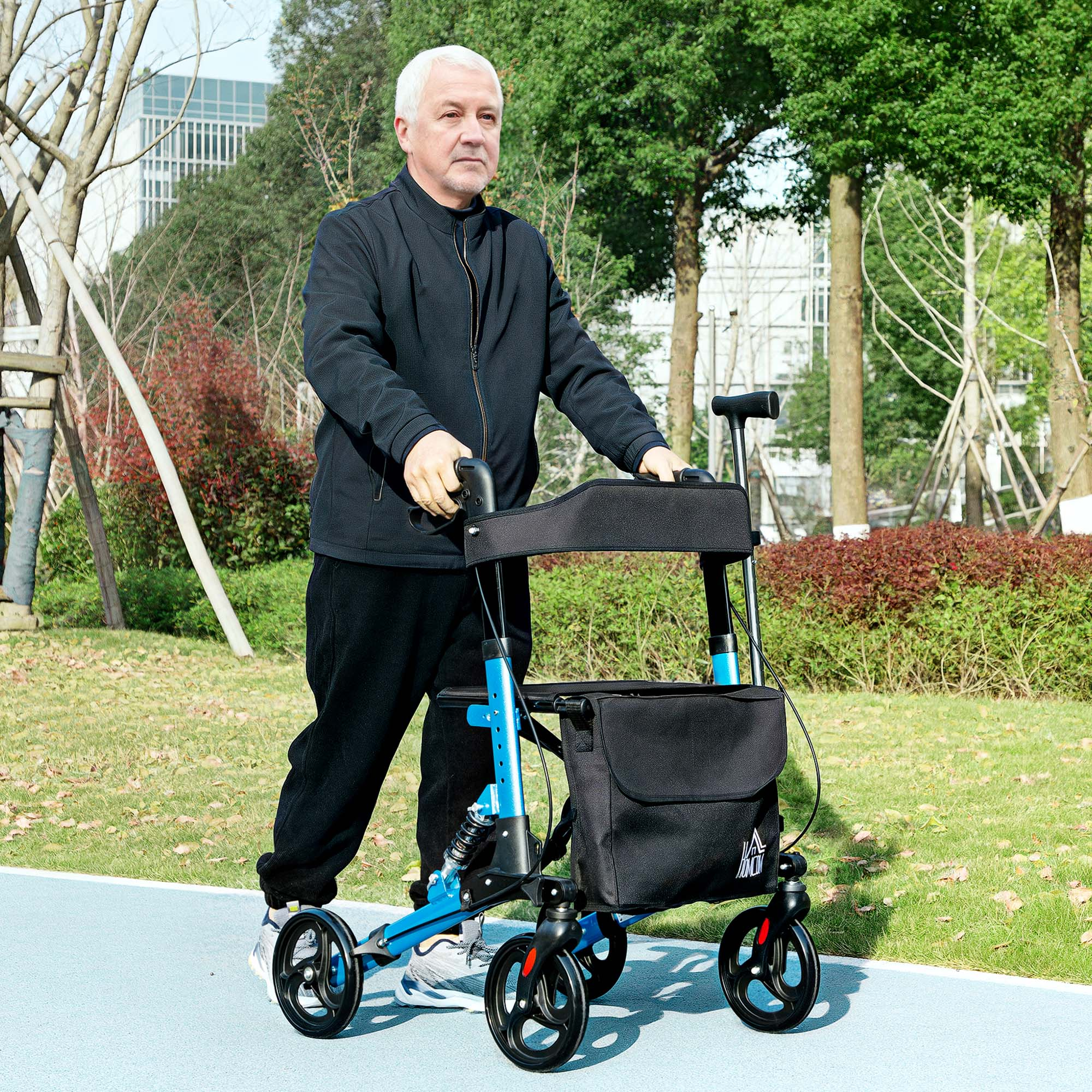 Un hombre mayor camina con un andador azul en un parque.