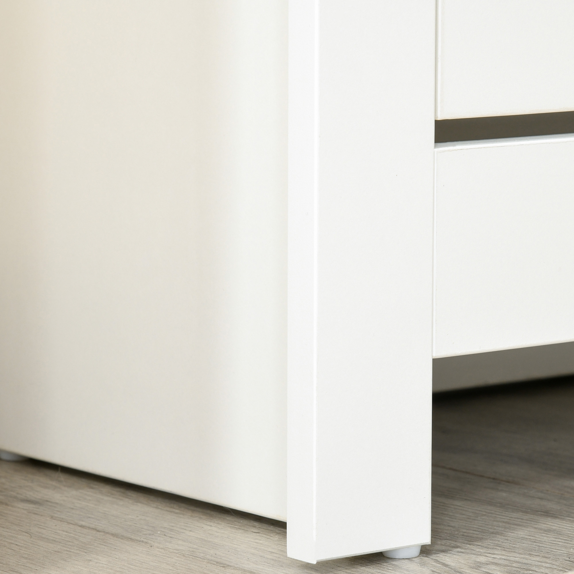 Frentes de muebles blancos sobre suelo de madera, con zócalo y patas.