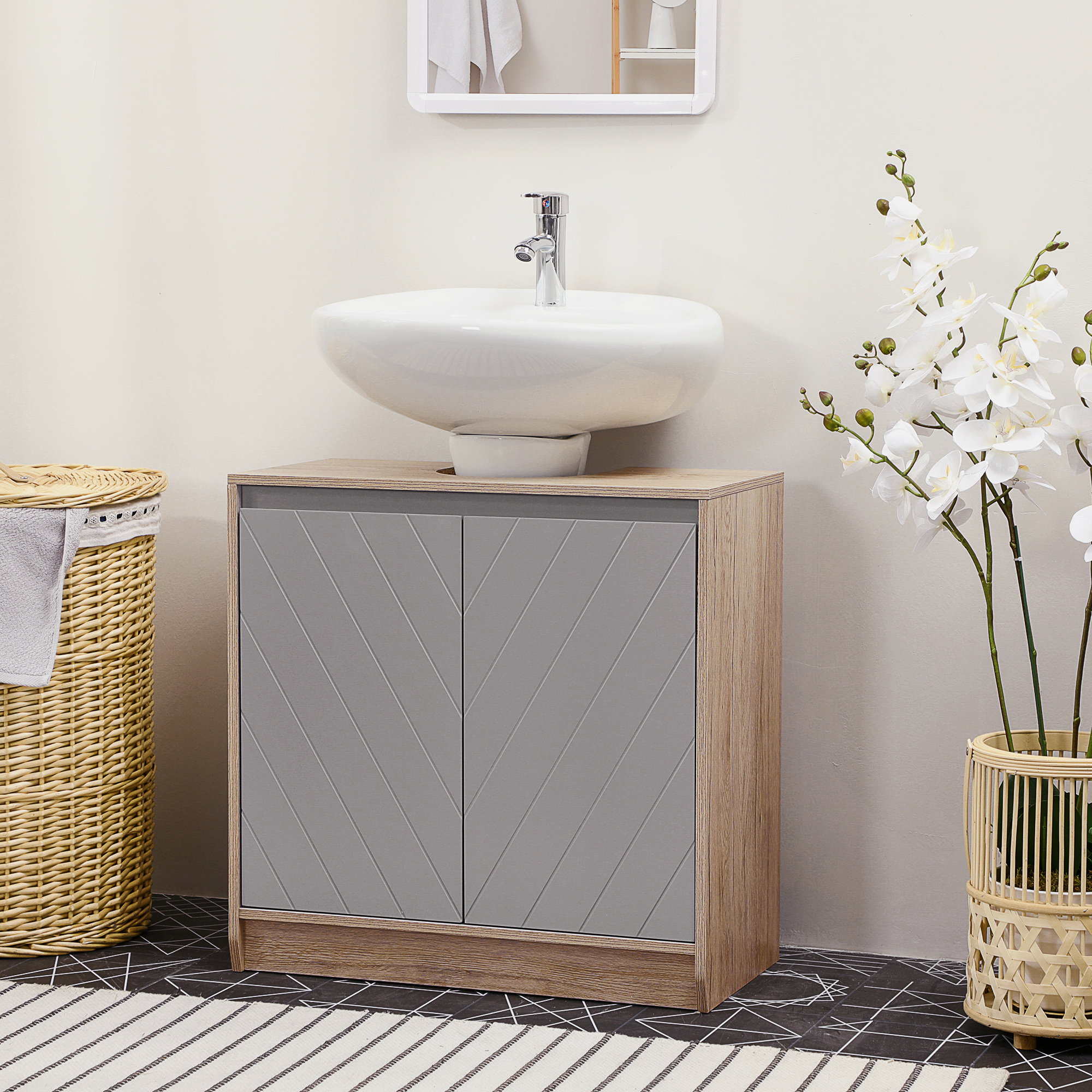 Baño con lavabo, armario, cesto de ropa y orquídeas.