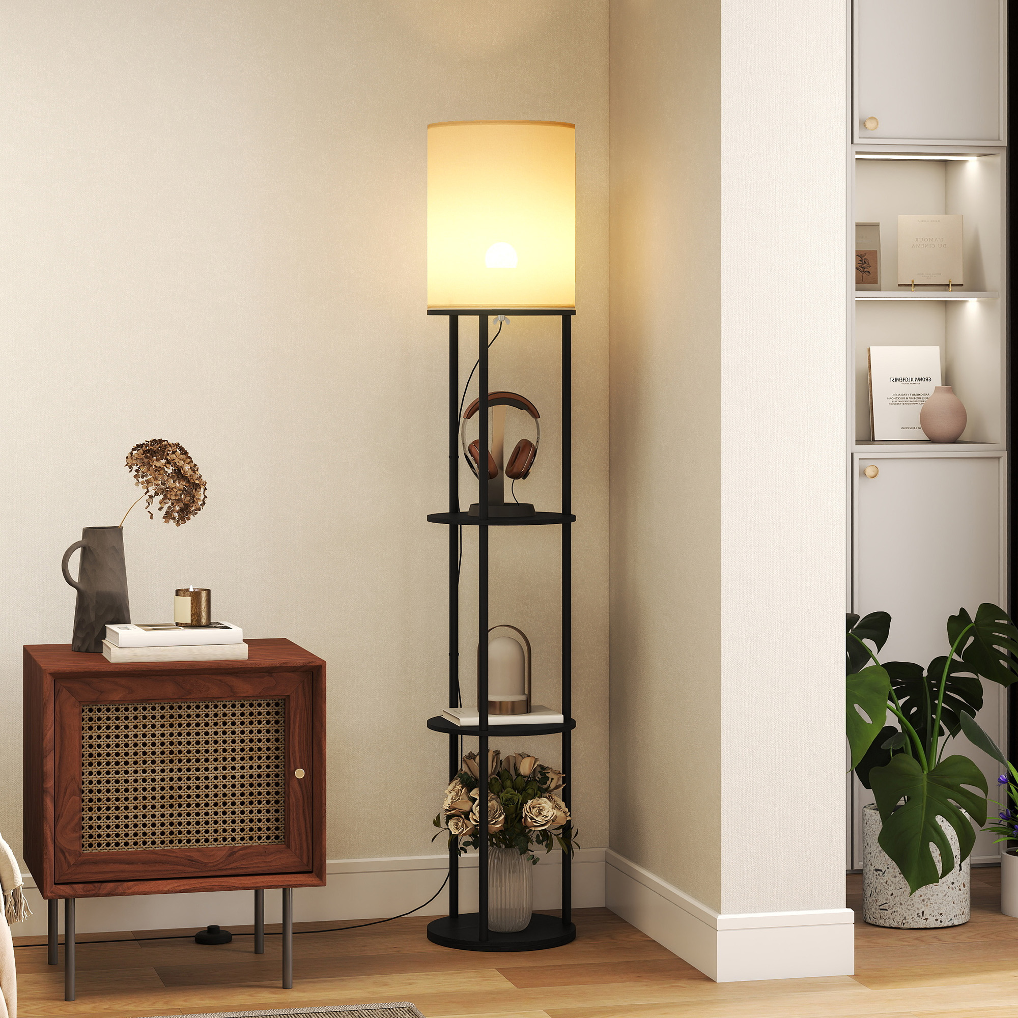 Una mesita de noche, lámpara de pie con estantes, auriculares, libros y plantas en una habitación.