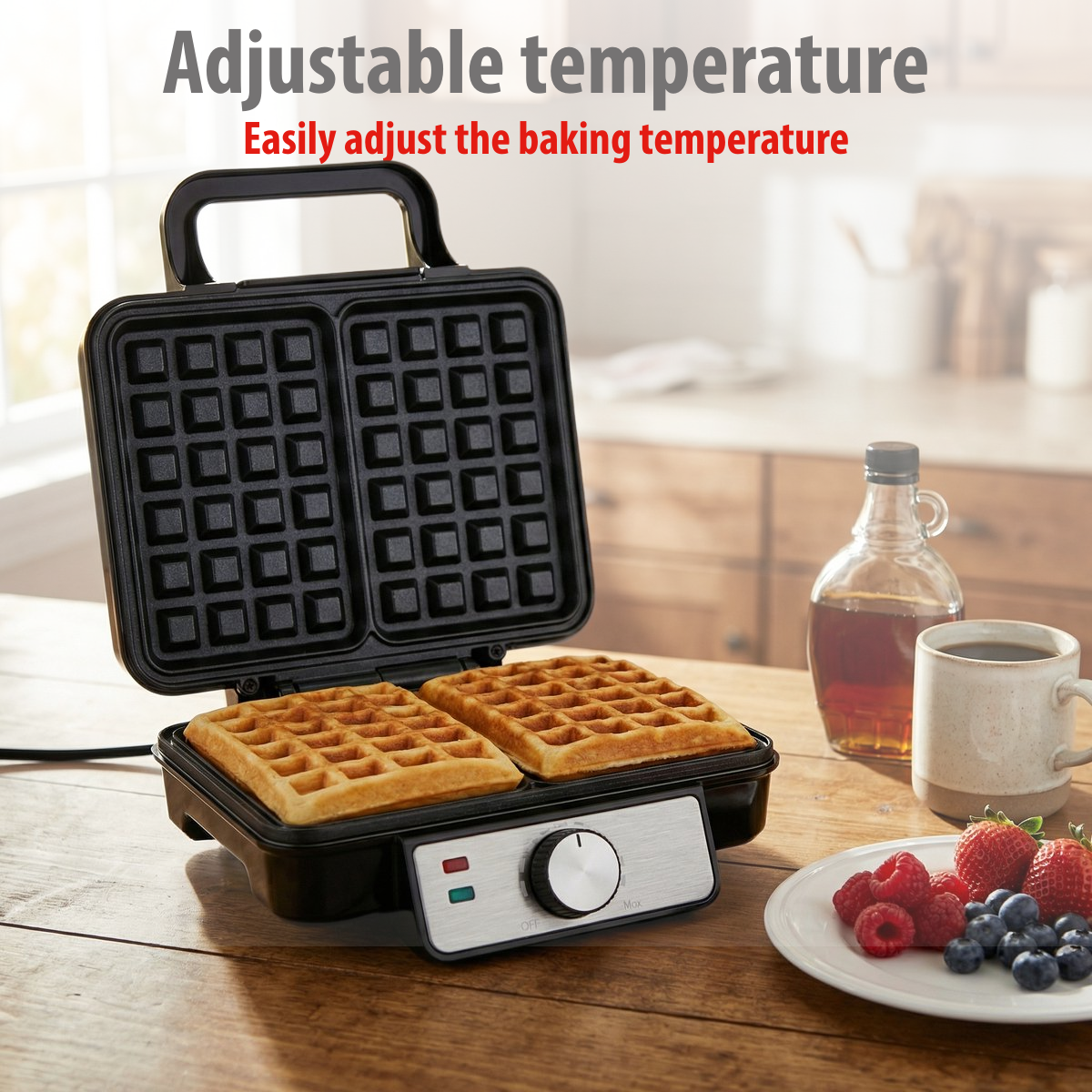 An open waffle maker with two golden waffles, berries and syrup nearby.