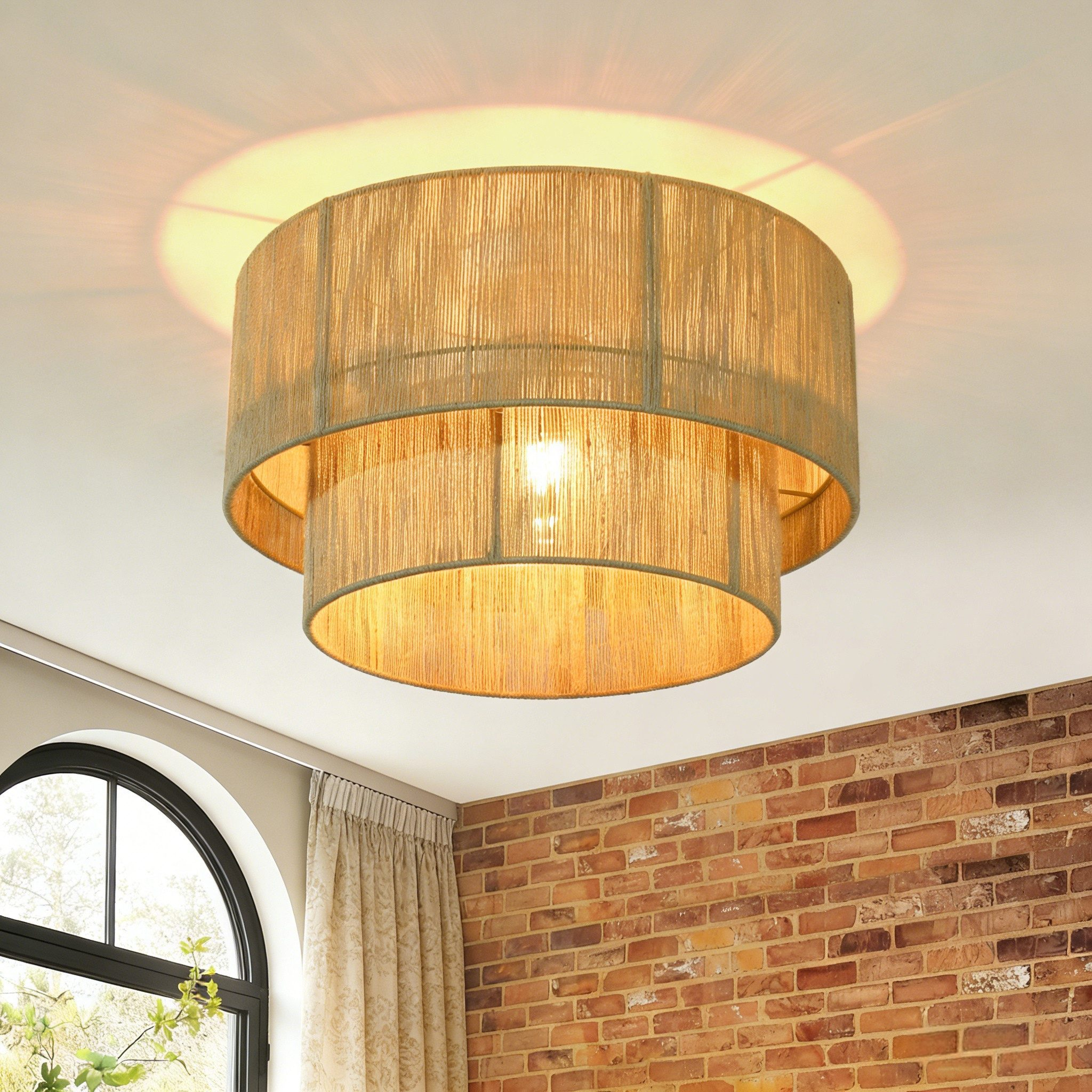 Lampada da soffitto in iuta a due livelli con tenda fantasia e parete in mattoni.