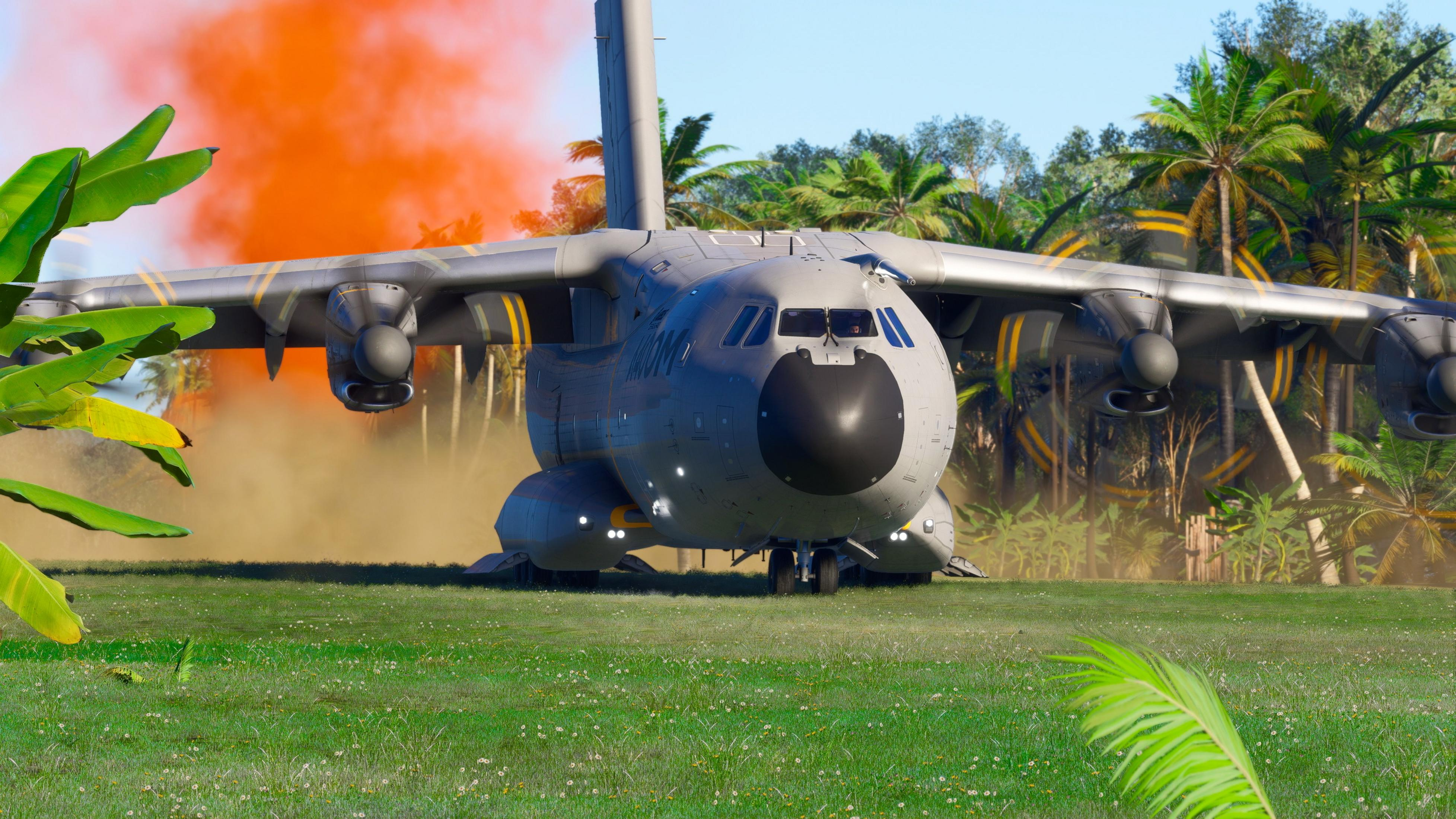 Un aereo militare grigio con fumo arancione atterra su un prato verde.
