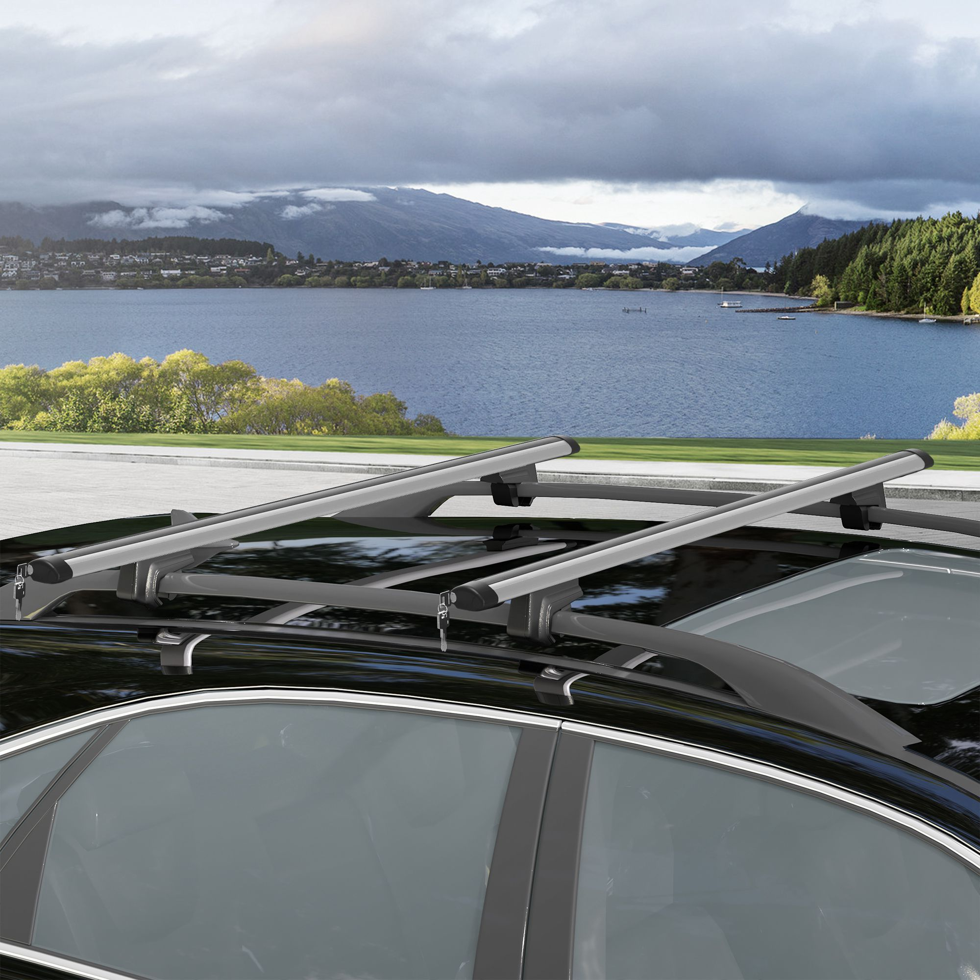SUV negro con portaequipajes en techo ante lago y montañas.