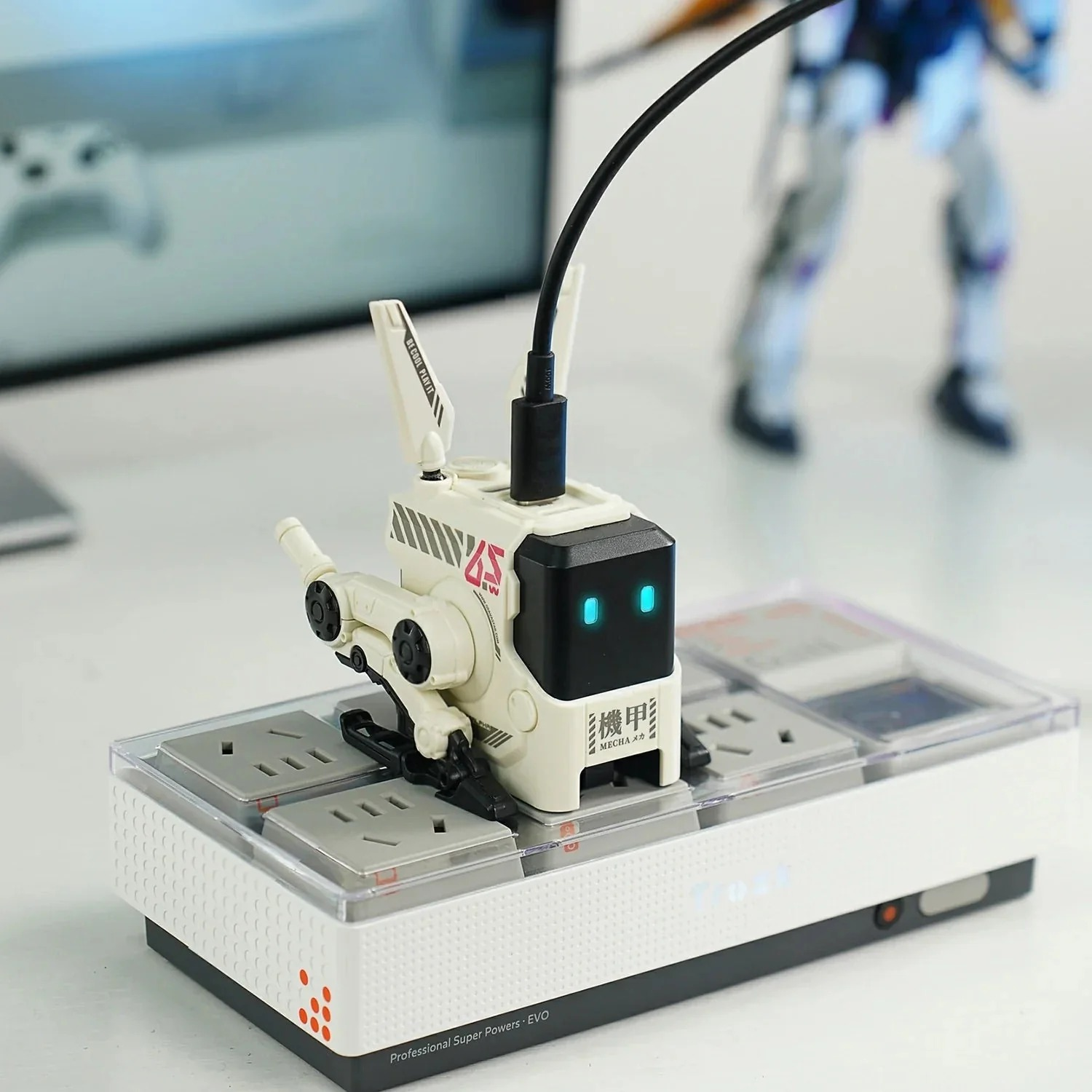 Biały robot stoi na białej listwie zasilającej z gniazdami.