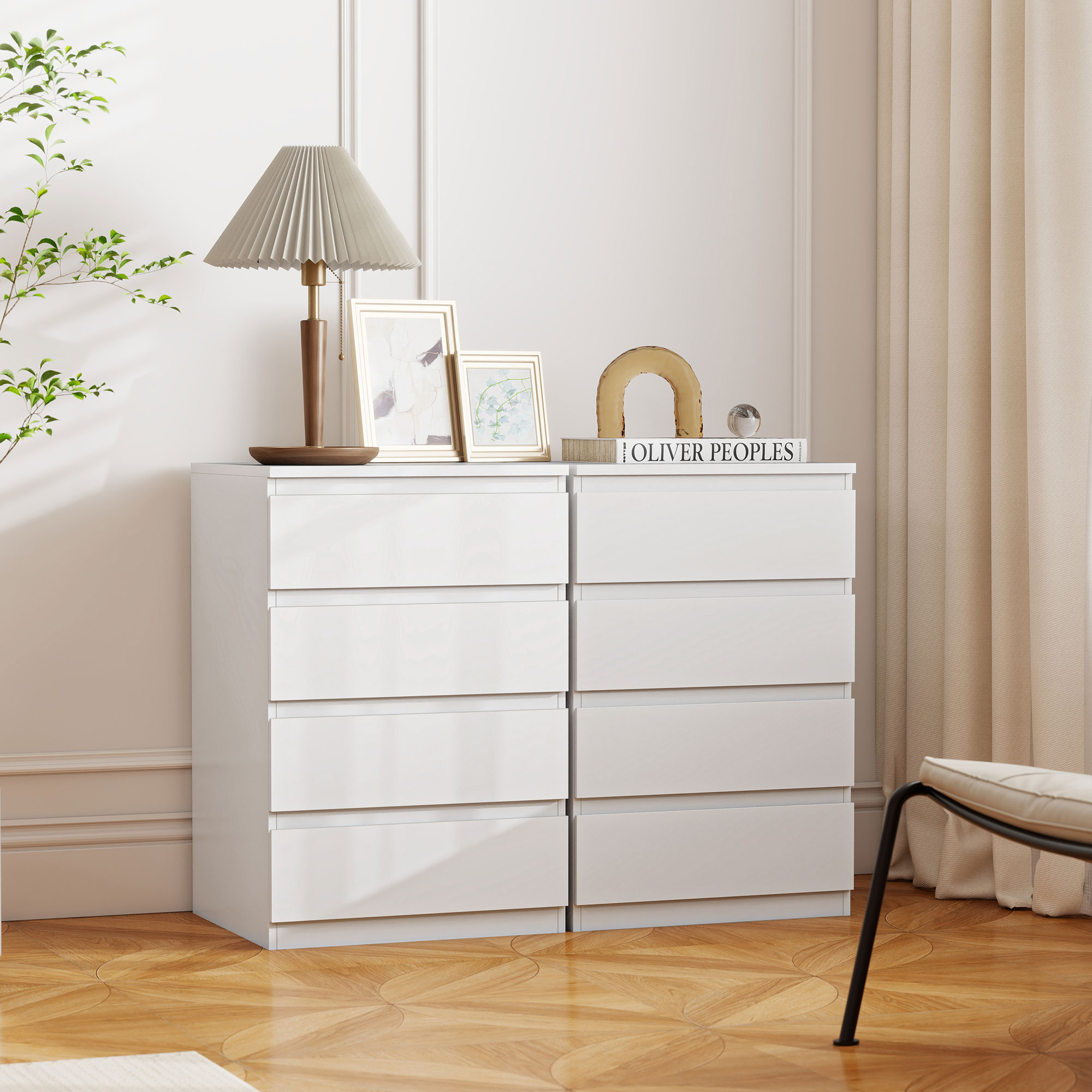 Dos cómodas blancas con decoración, lámpara y marcos de fotos.