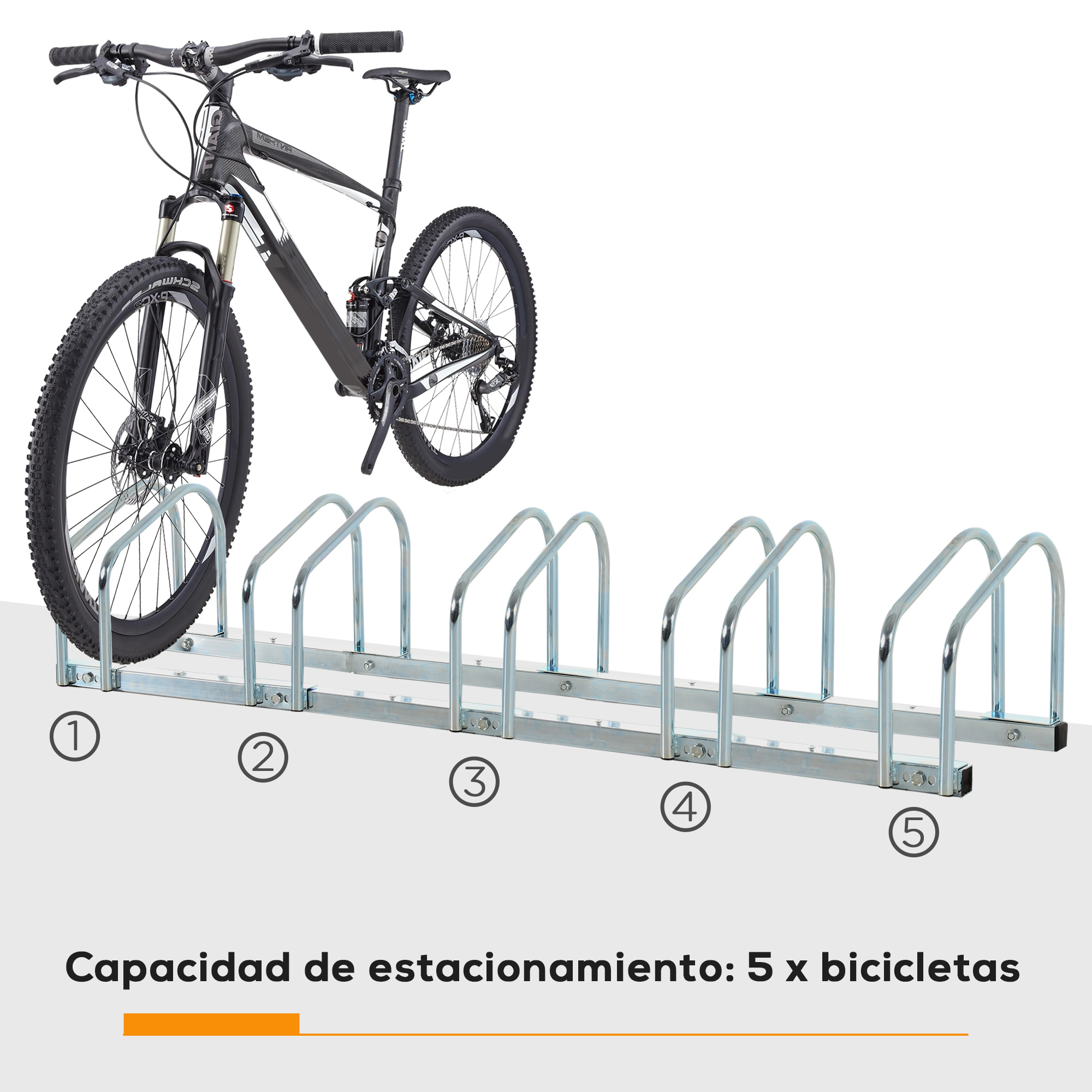 Una bicicleta de montaña delante de un aparcamiento plateado para 5 bicicletas.