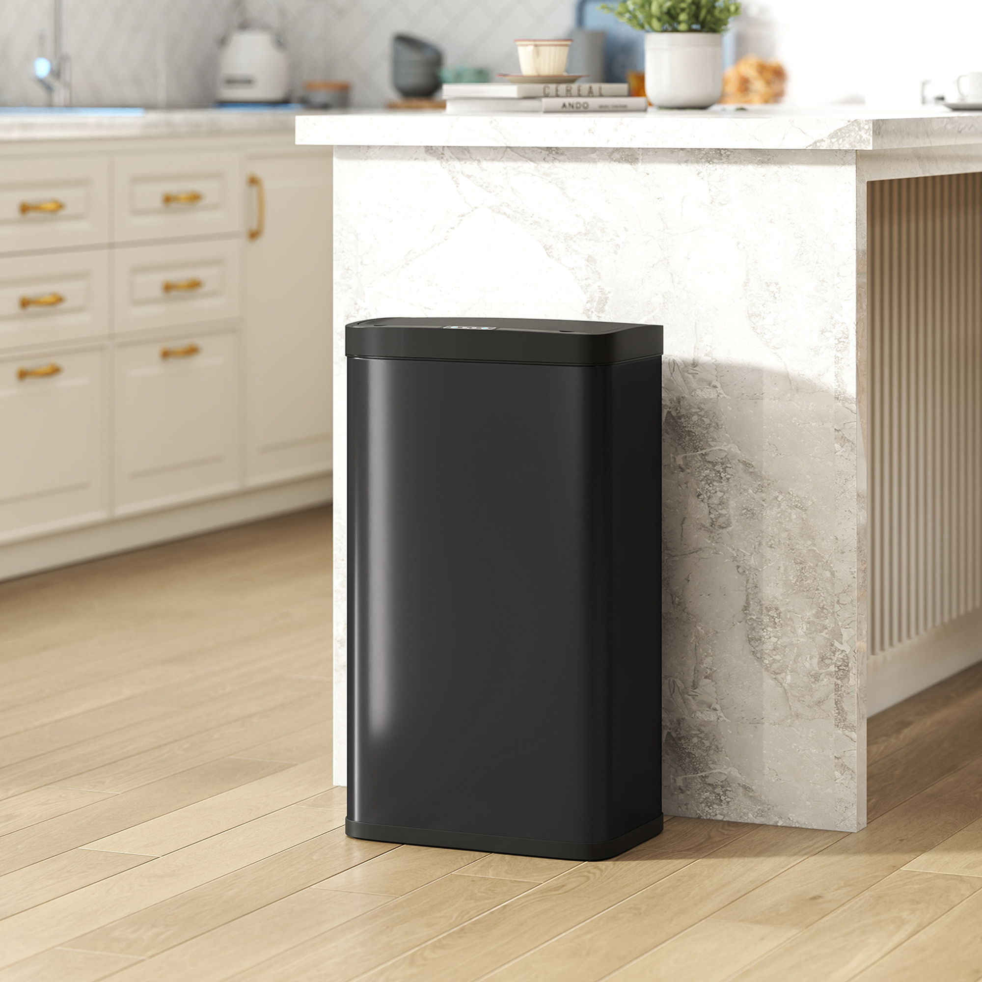 Un cubo de basura negro está en un suelo de madera junto a una isla de cocina.