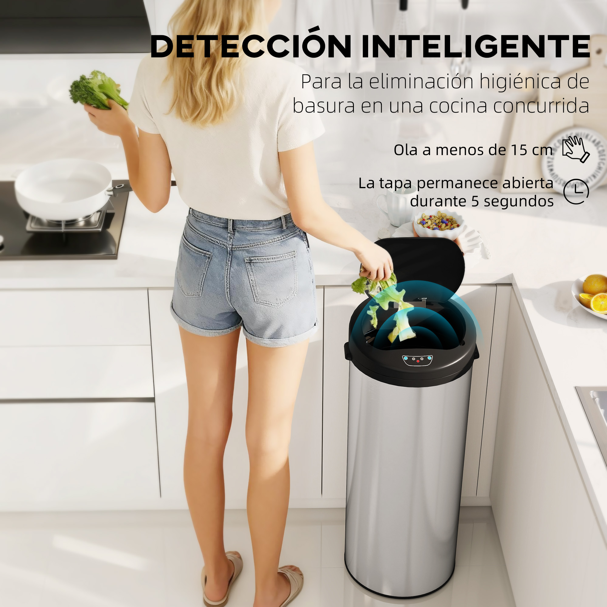 Mujer arroja brócoli a un cubo de basura plateado con apertura automática en una cocina.