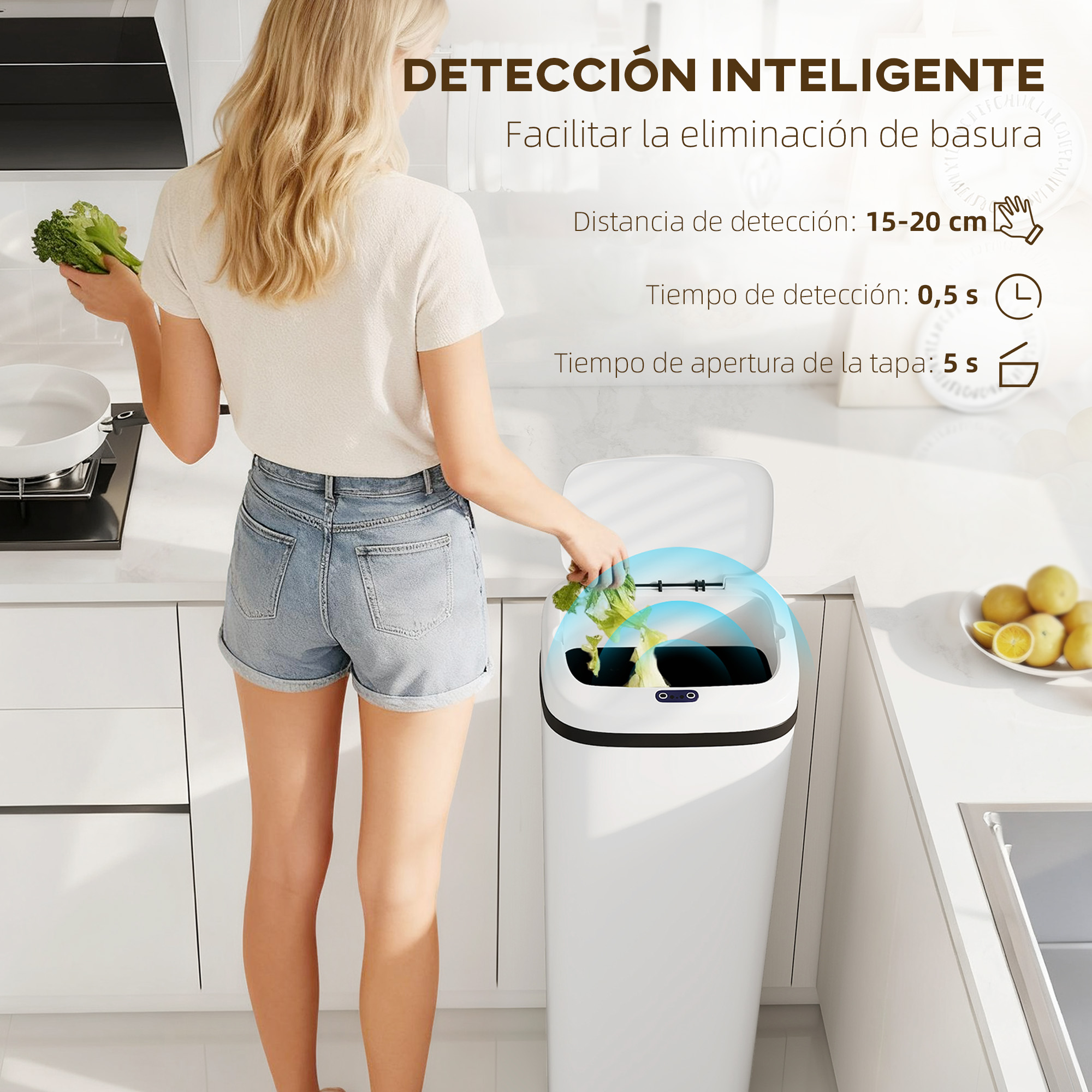 Mujer tira basura en un cubo blanco con sensor. Cocina con fruta al fondo.