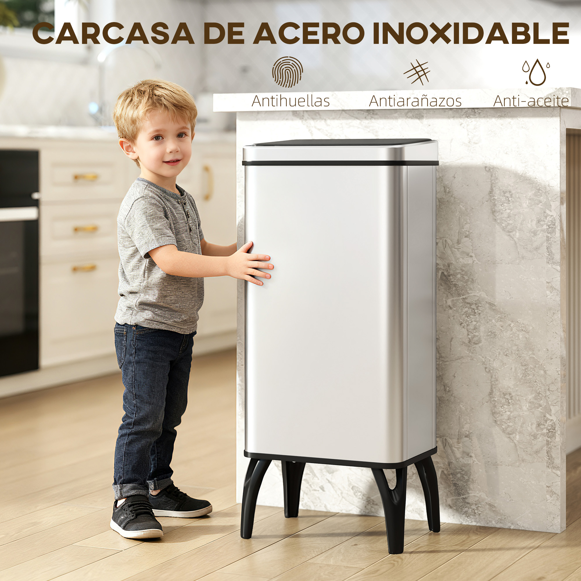 Un niño junto a un cubo de basura plateado en una cocina. Anti huellas.