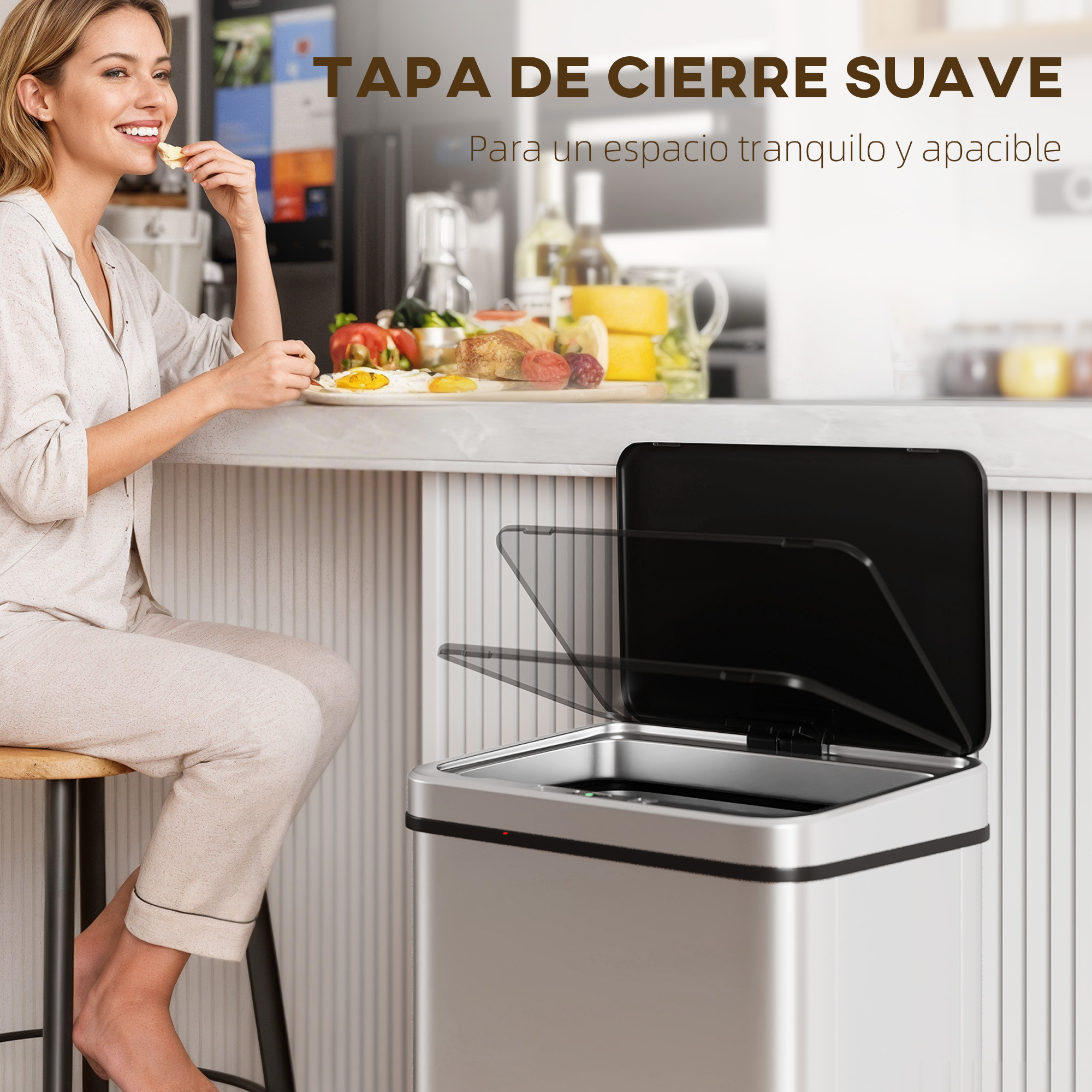 Mujer desayuna en el mostrador junto a un cubo de basura plateado con tapa abierta.