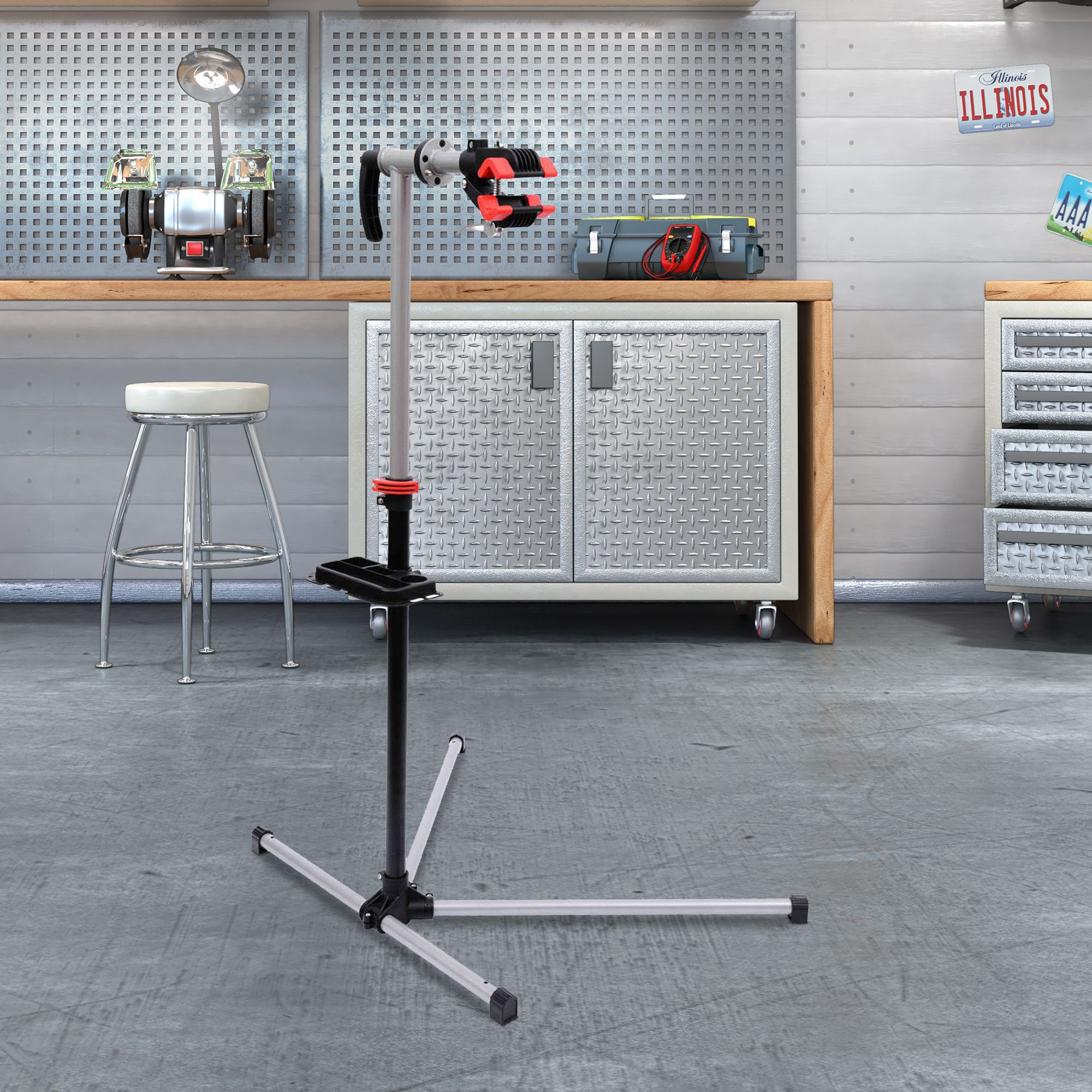 Un soporte de reparación de bicicletas con herramientas y taburete en un garaje.