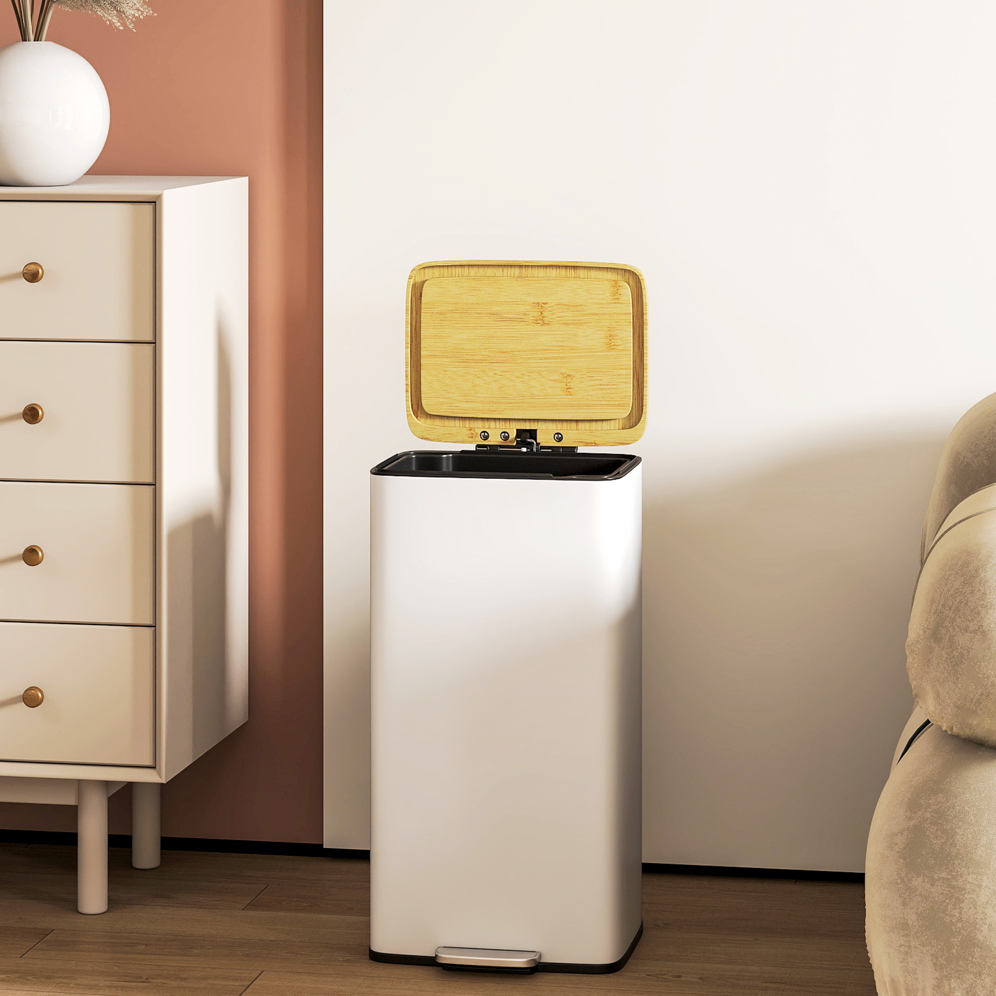 Un cubo de basura blanco con tapa de madera junto a una cómoda y un sofá.