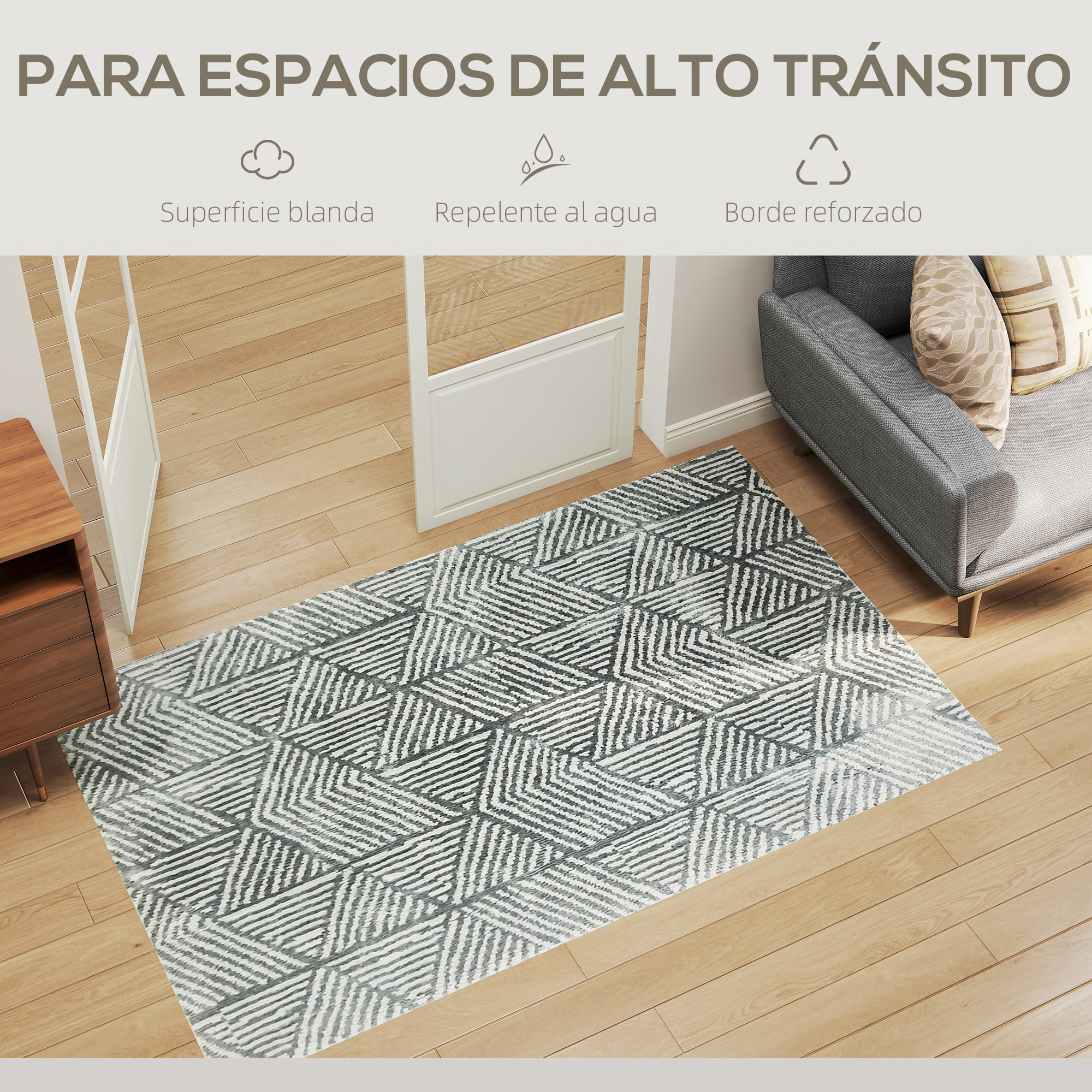 Alfombra gris con patrón geométrico sobre suelo de madera, junto a sofá.