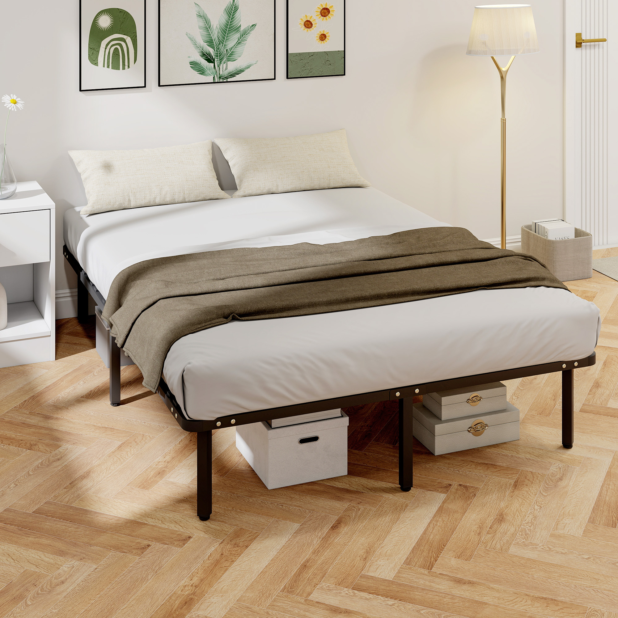 Una cama con sábanas blancas, almohadas y una manta marrón descansa sobre un suelo de madera.