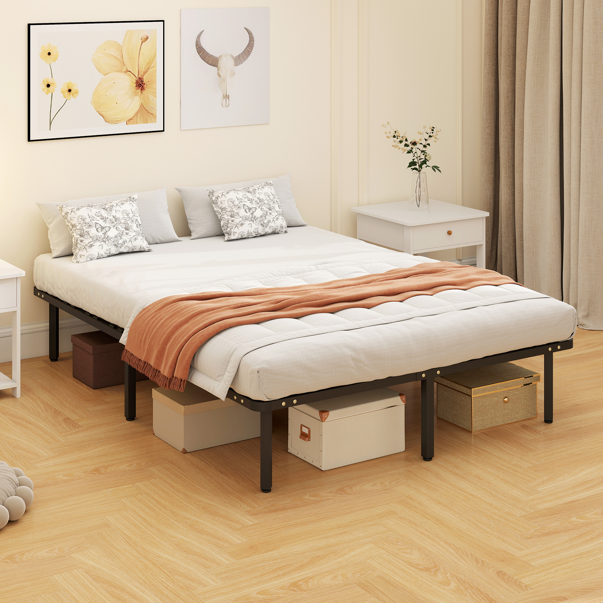 Una base de cama de metal con ropa de cama blanca, manta naranja y cojines.