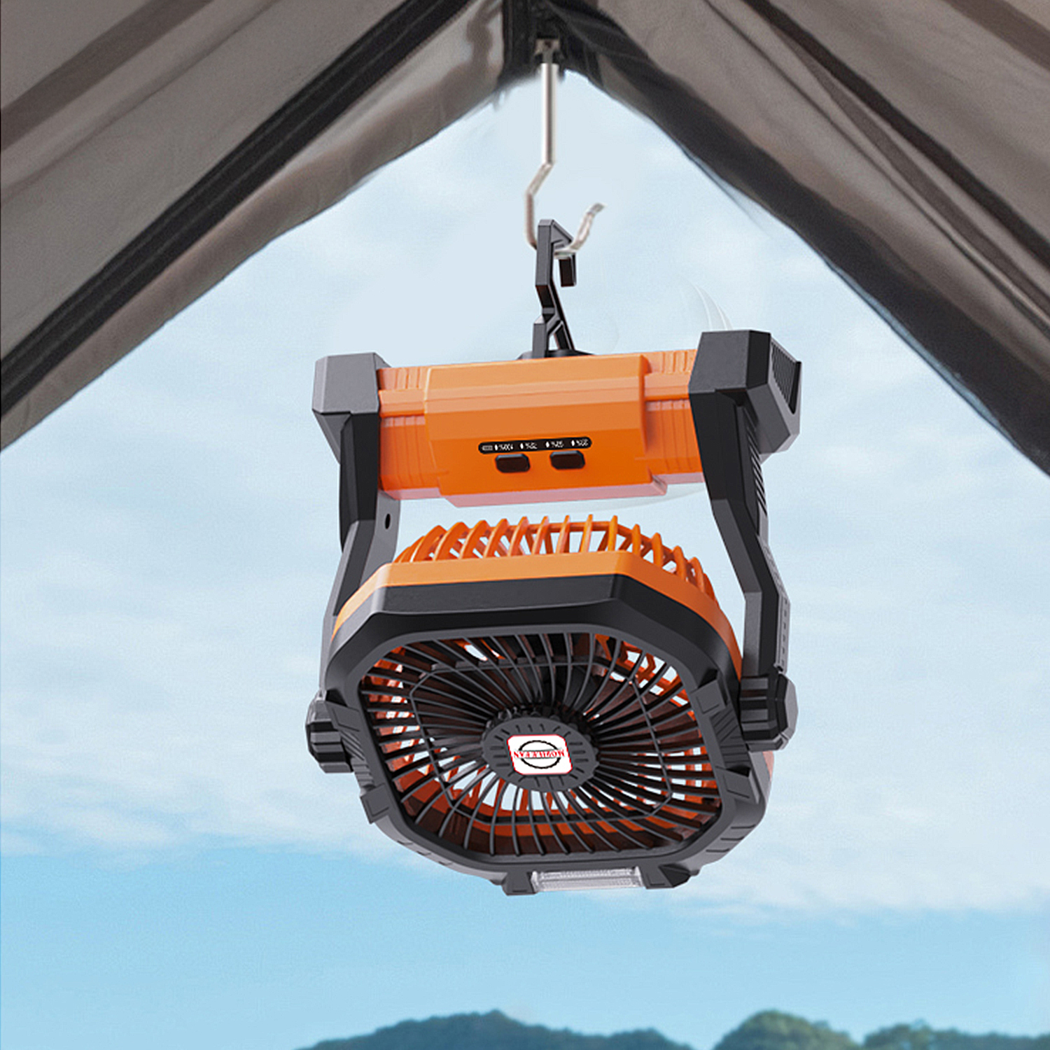 Ventilatore da campeggio arancione con lanterna appeso a una tenda sotto un cielo blu.