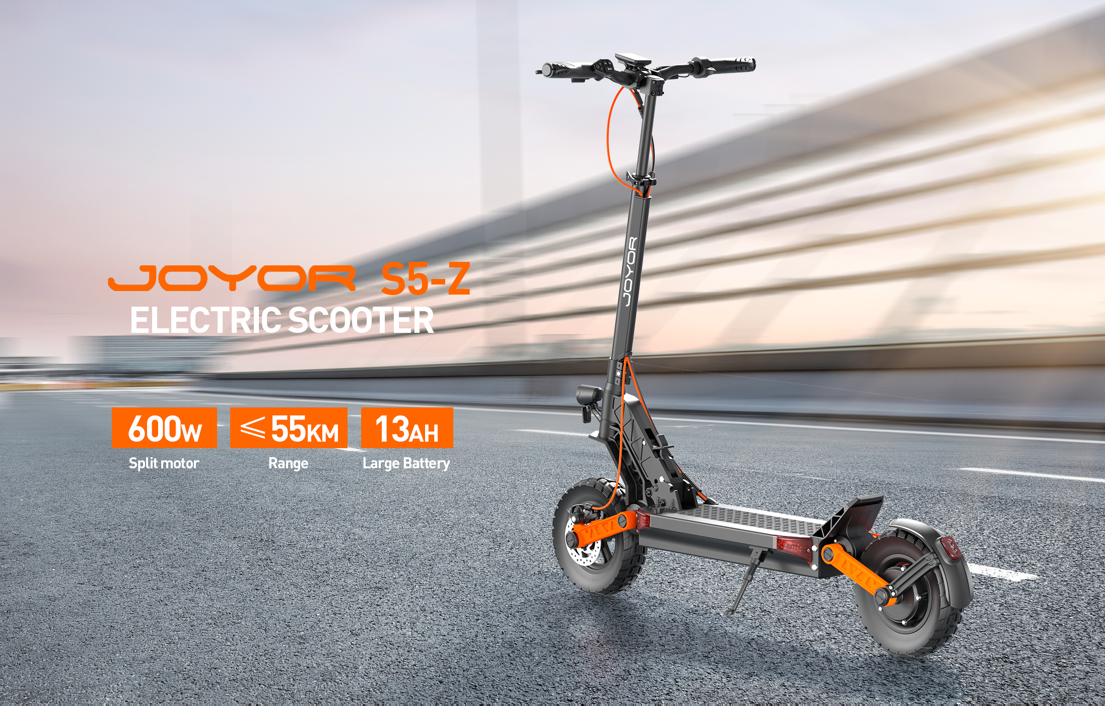 Uno scooter elettrico Joyor S5-Z nero con accenti arancioni su strada asfaltata.