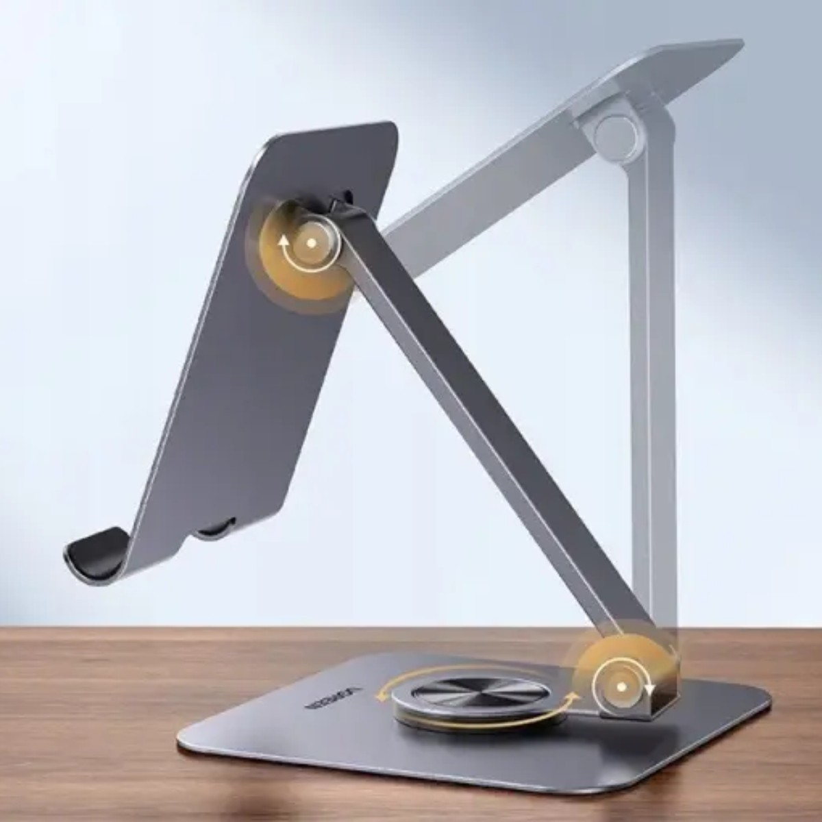 Składany metalowy stojak na tablet na drewnianym stole.