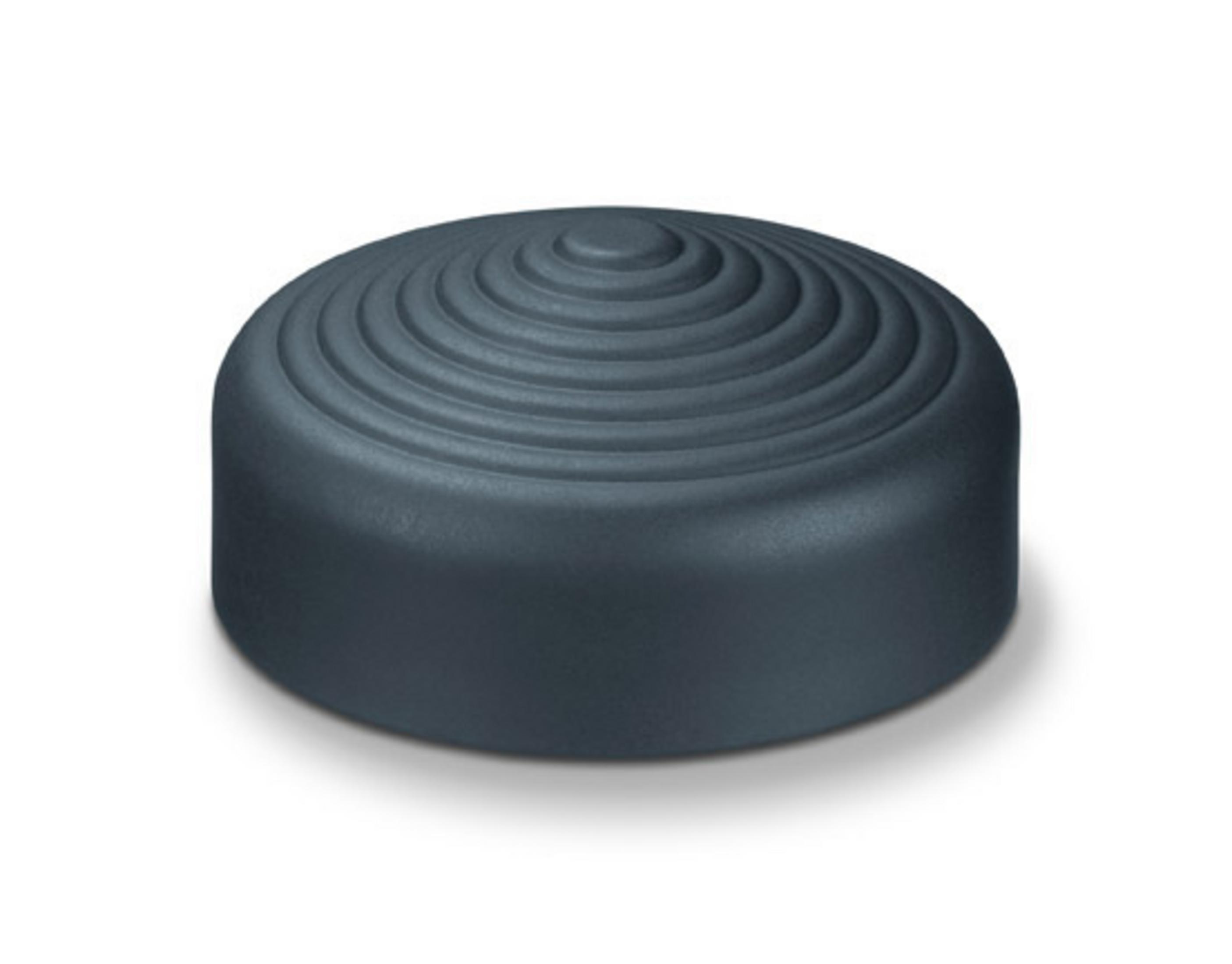 Un pouf rotondo scuro con cerchi concentrici sulla superficie superiore.