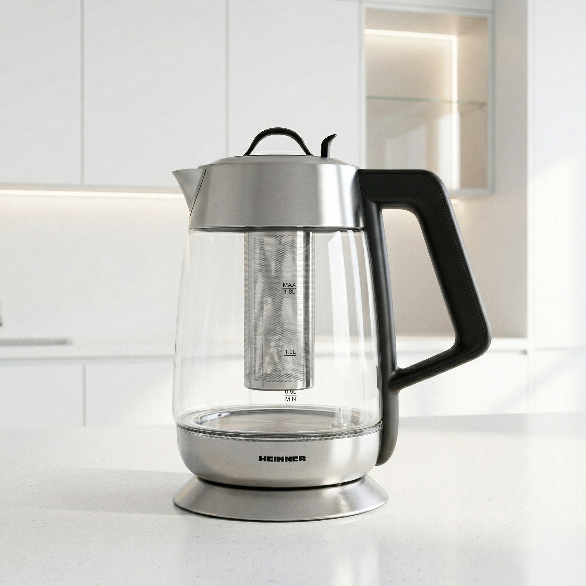 Une bouilloire en verre avec base en acier inoxydable, poignée noire et infuseur.