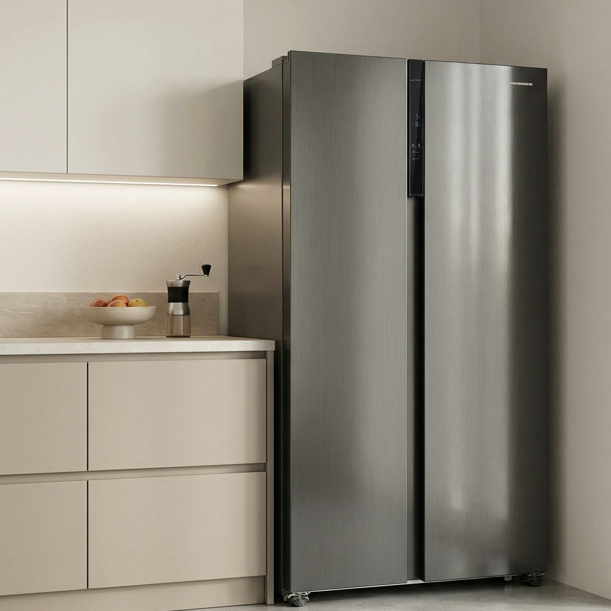 Een moderne, zilverkleurige koelkast met dubbele deuren staat in een keuken naast crèmekleurige kasten.