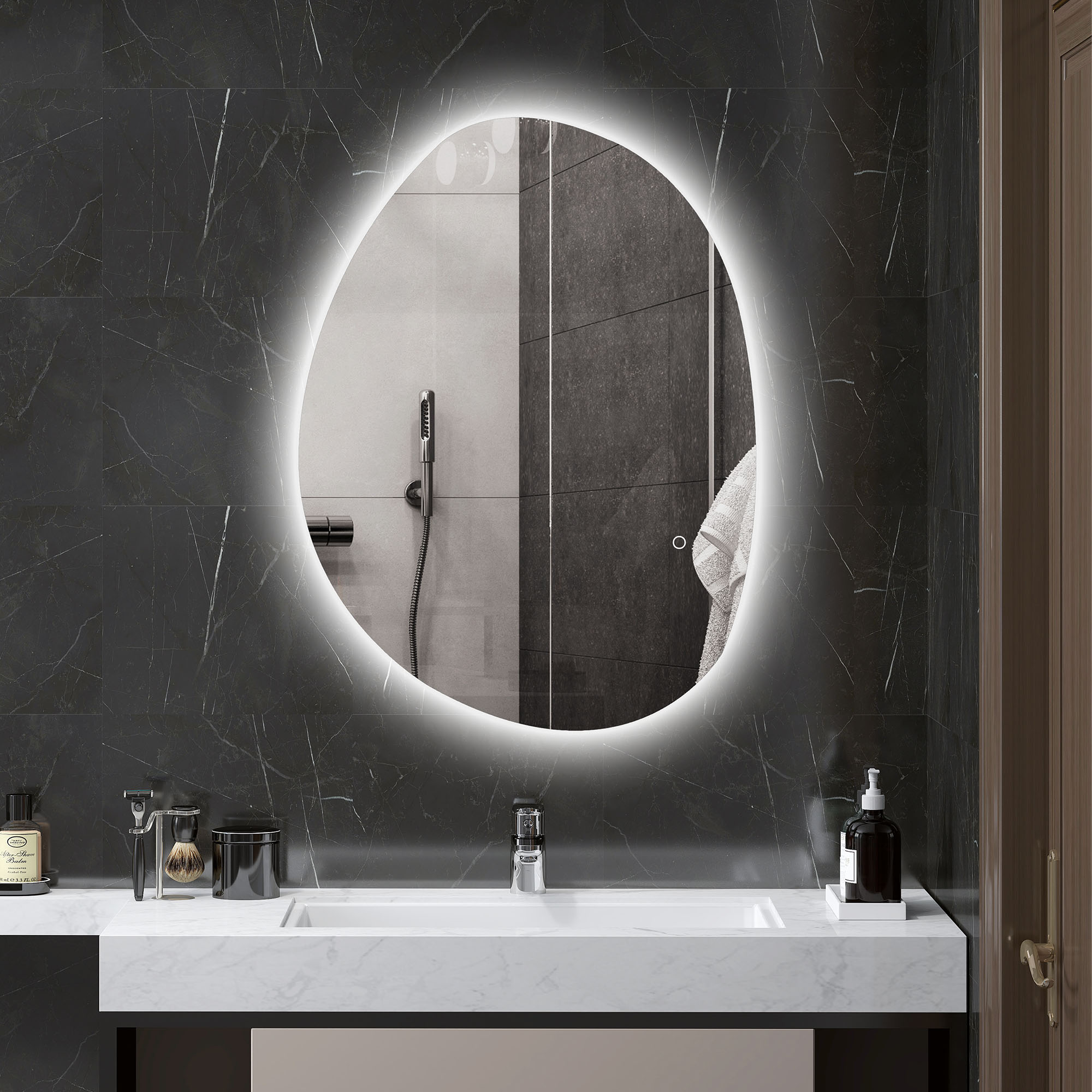 Un espejo ovalado retroiluminado sobre un lavabo con grifos y artículos de tocador.