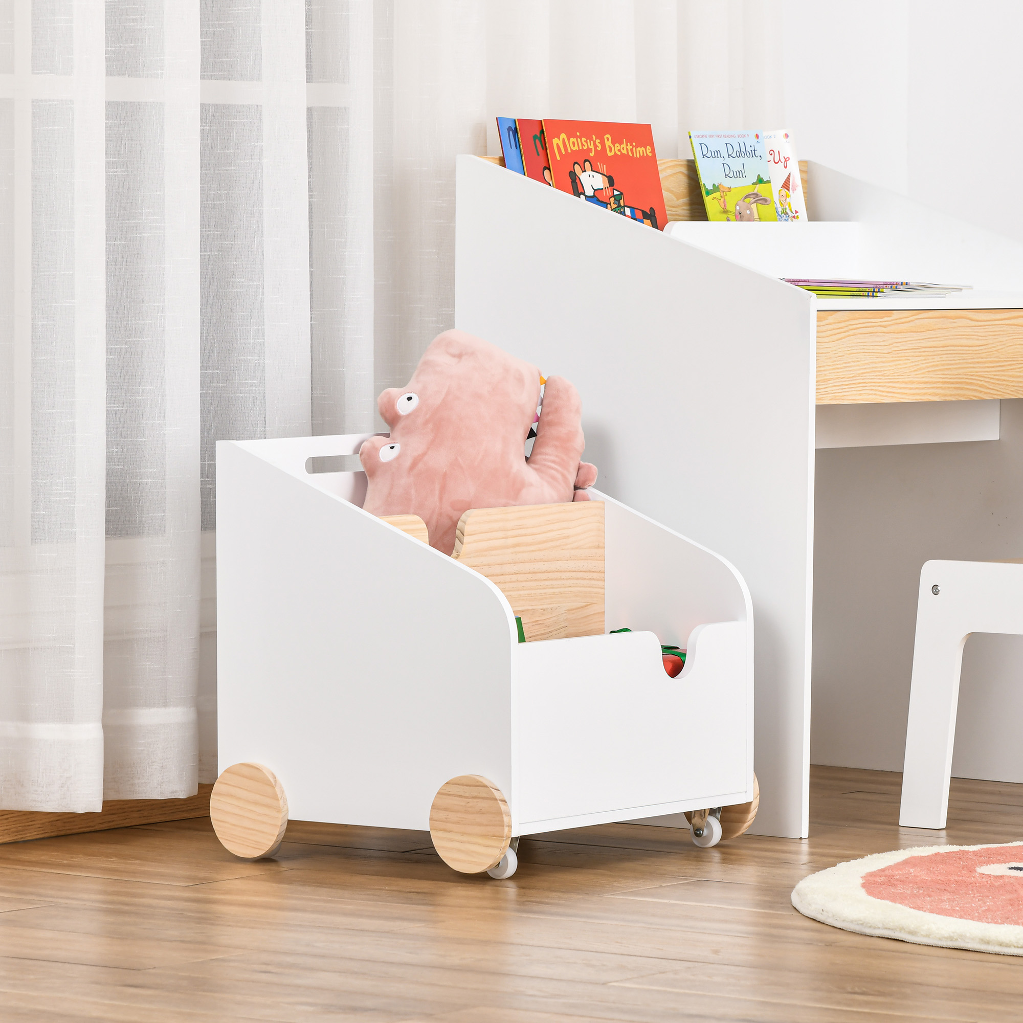 Un carro de juguete blanco con ruedas contiene un peluche rosa y bloques de madera.