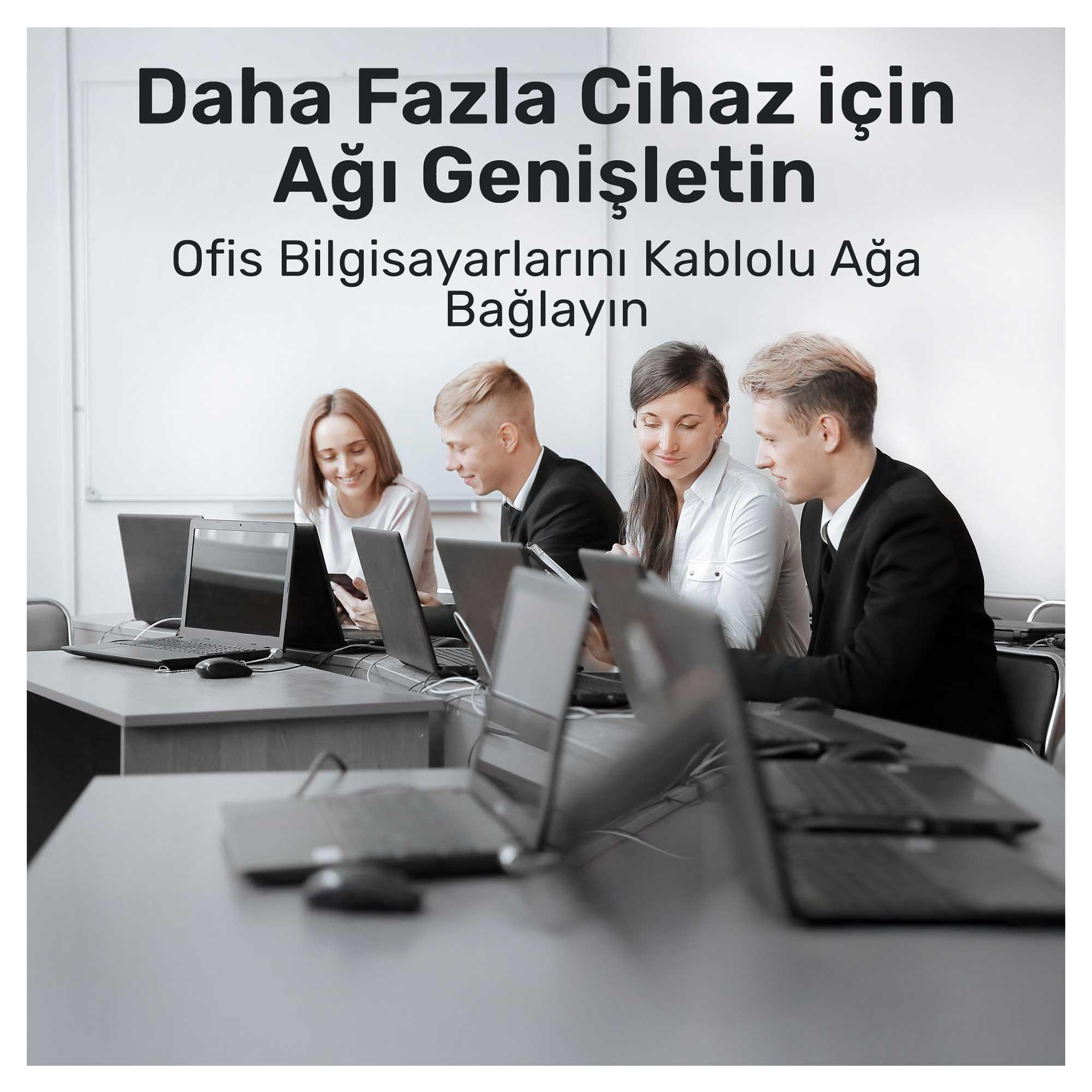 Büroangestellte arbeiten an Laptops in einem Klassenzimmer.