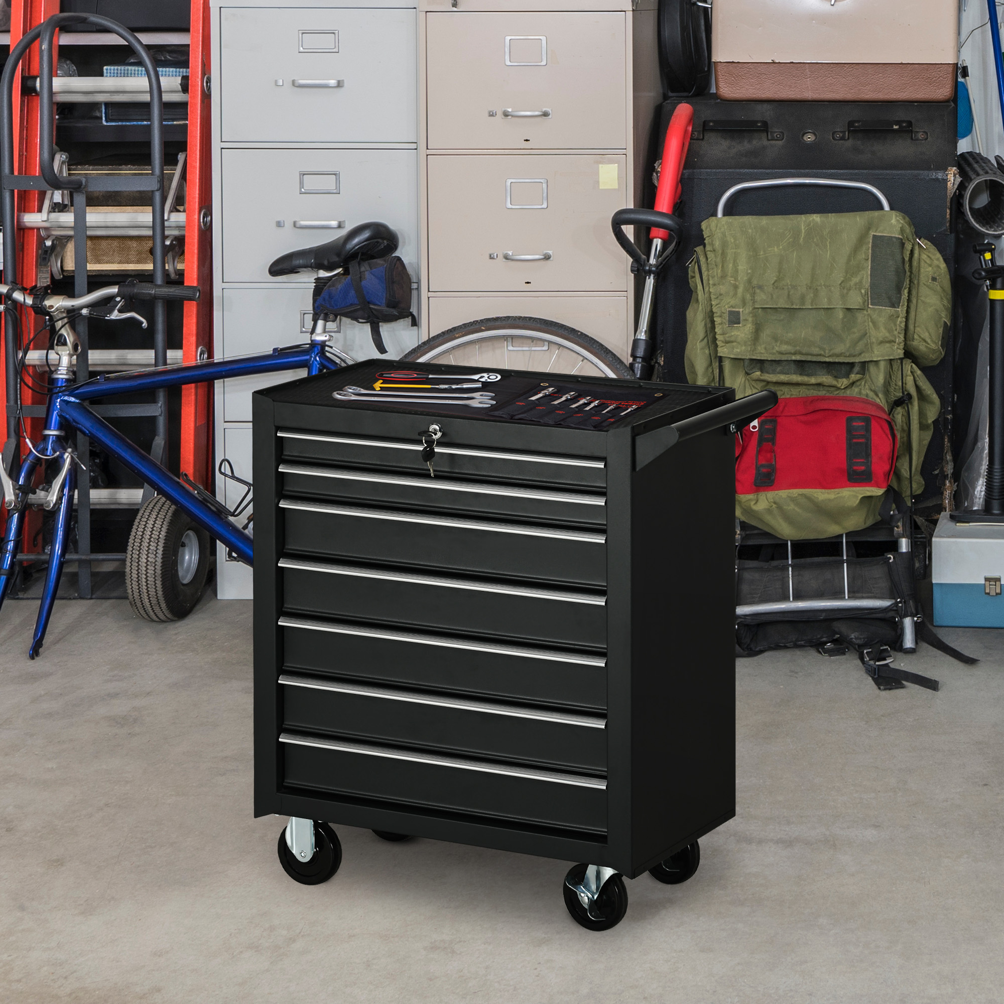 Caja de herramientas negra con herramientas, al lado una bicicleta azul y un carro portaescaleras rojo.