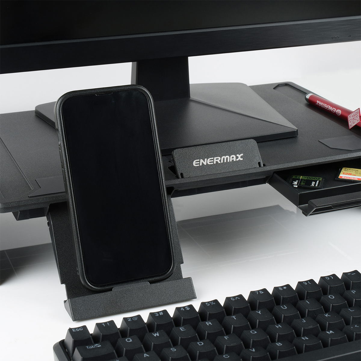 Monitör, klavye ve hafıza kartları önünde stantta bir akıllı telefon.