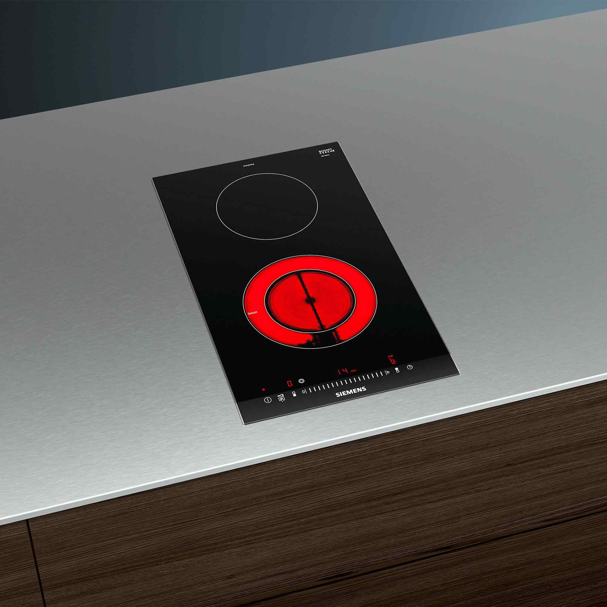 Czarna płyta indukcyjna z dwoma strefami grzania, jedna świeci na czerwono.