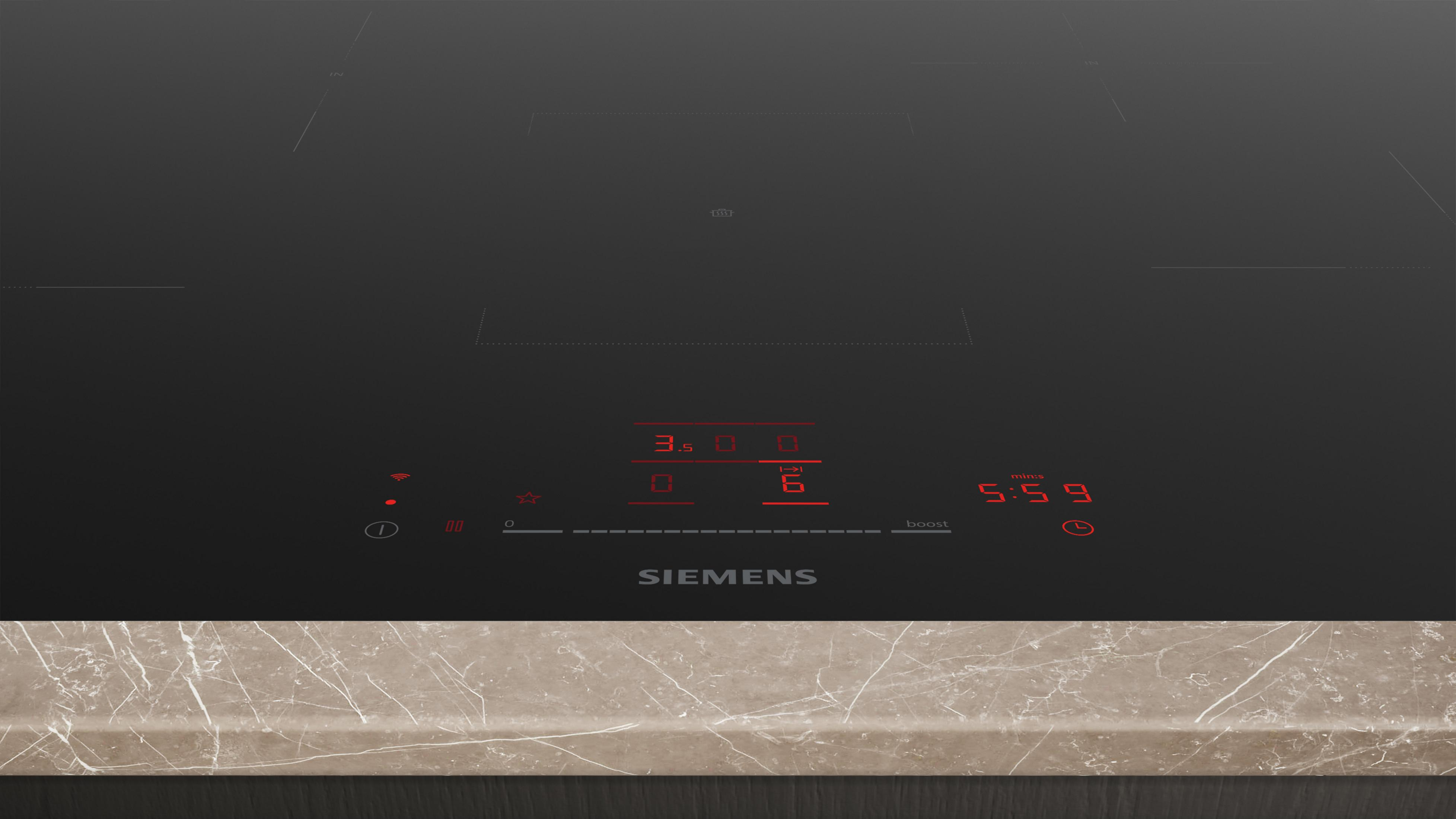 Plaque à induction noire avec écran numérique rouge et plan de travail en marbre.