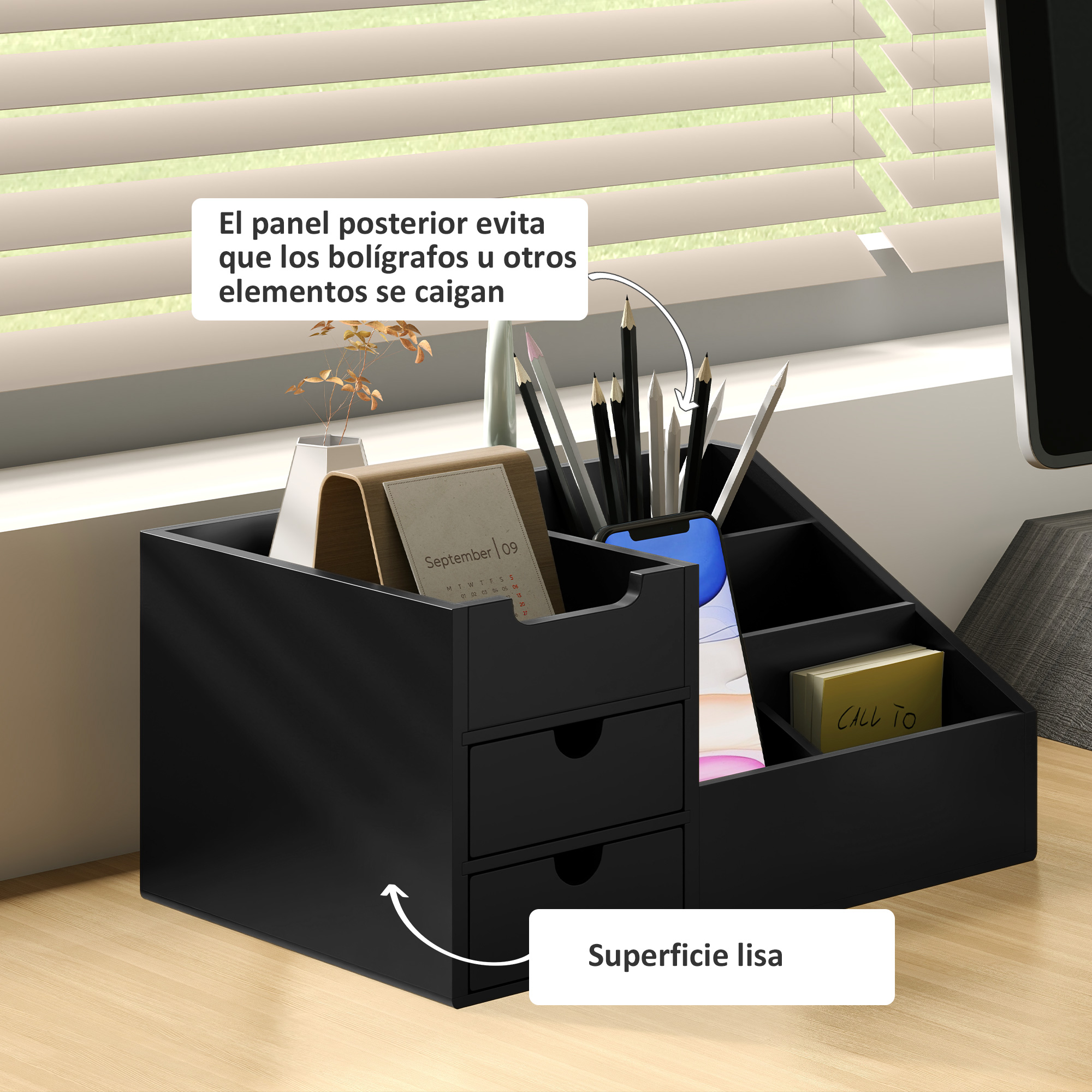 Organizador de escritorio negro con cajones, bolígrafos, calendario y teléfono.