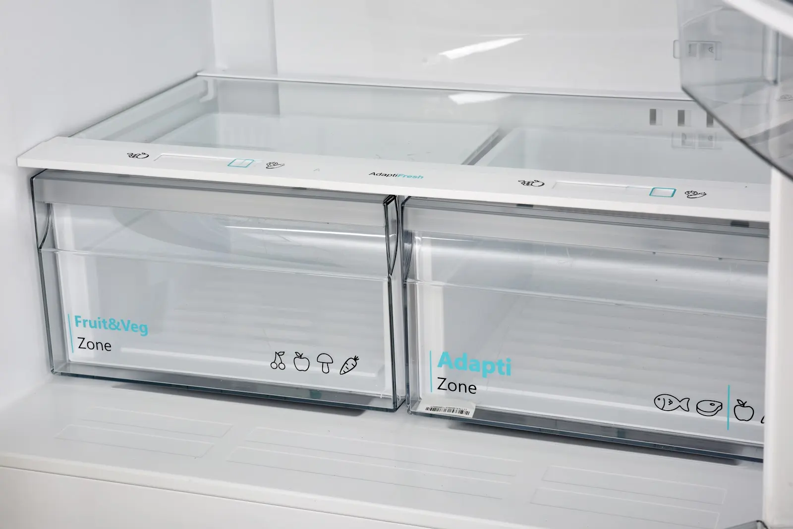 Two clear refrigerator drawers, one labeled Fruit&Veg Zone, the other Adapti Zone.