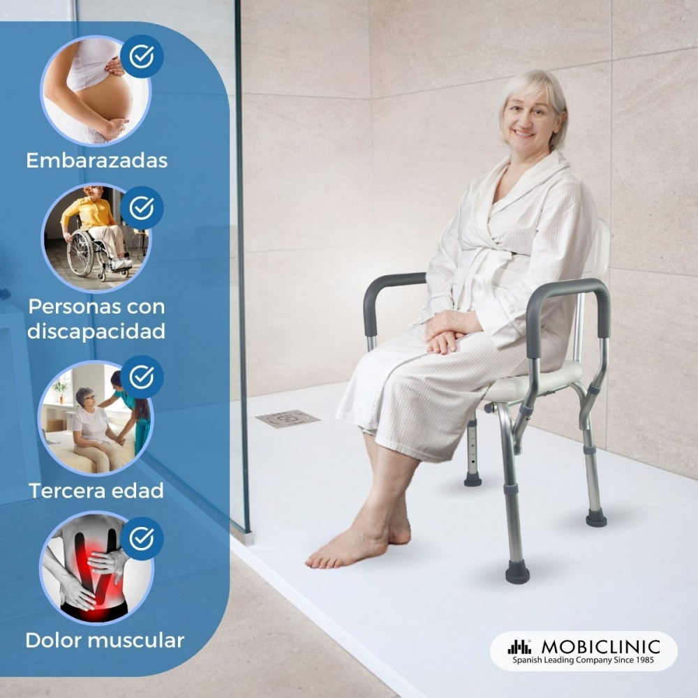 Una mujer mayor sentada en una silla de ducha en un baño moderno.