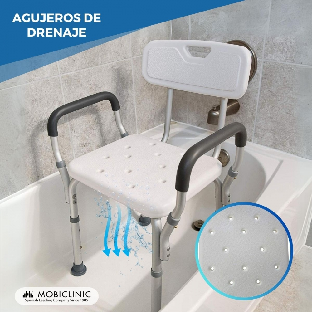 Una silla de ducha con reposabrazos está en una bañera. El agua fluye por los agujeros del asiento.