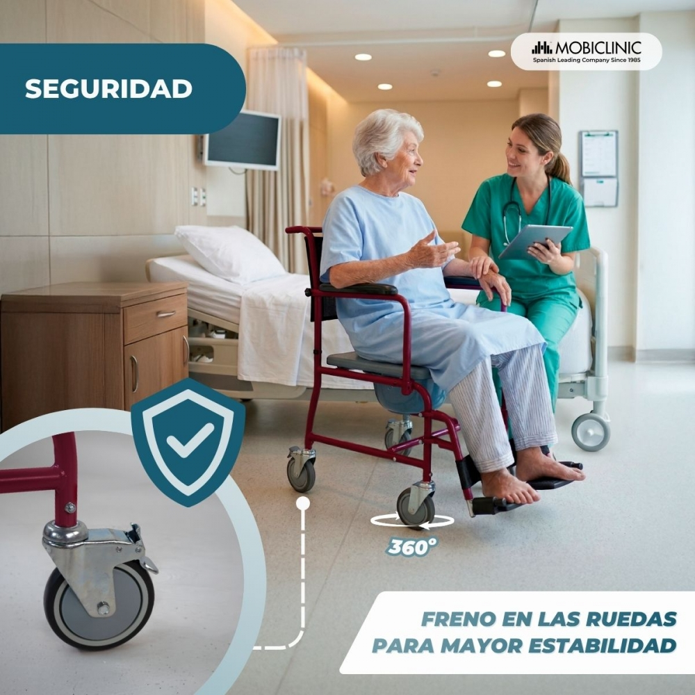 Mujer mayor en silla de ruedas habla con enfermera en sala de hospital.