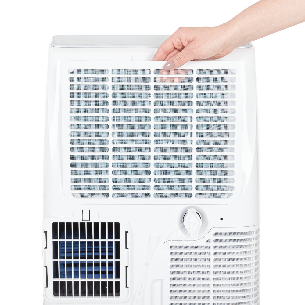 Ręka wyciąga biały filtr z klimatyzatora.