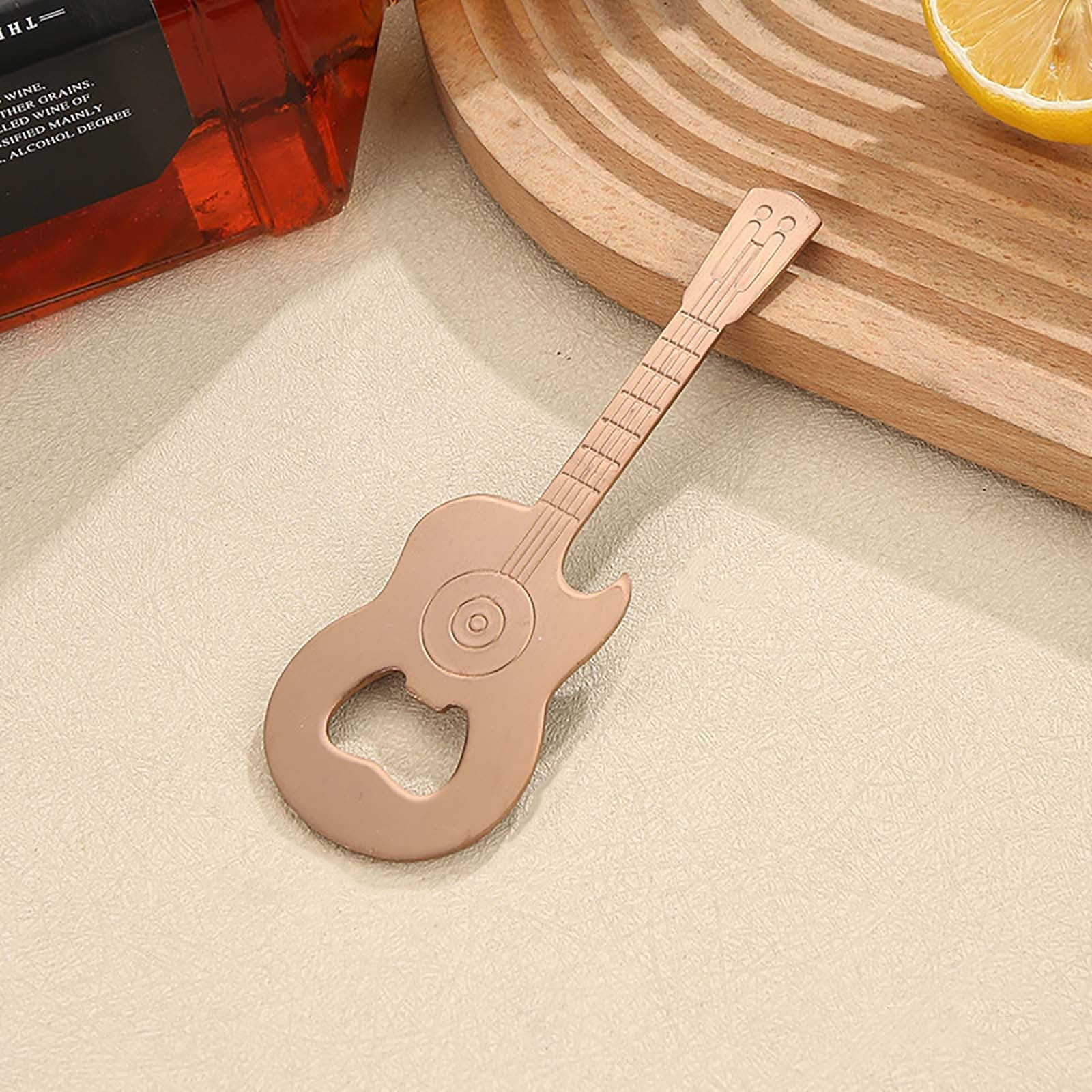 Ein flaches, gitarrenförmiges Flaschenöffner-Werkzeug auf einer hellen Oberfläche.